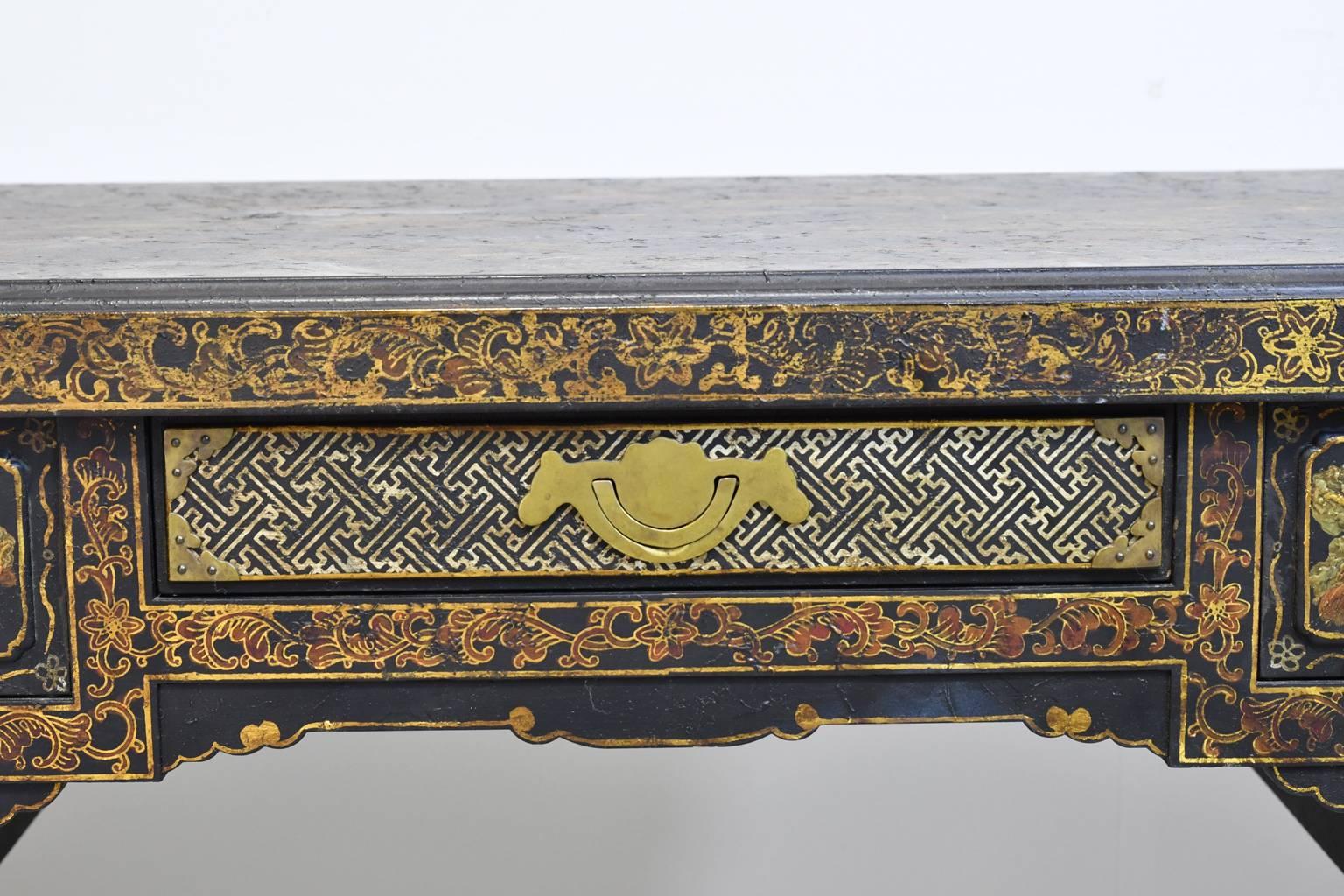 An authentic reproduction of a Chinese writing table that was imported into England during the Queen Anne period (1702-1714) with cordovan-leather lacquer finish with delicately-rendered Chinese genre scenes, decorative motifs and patterns like