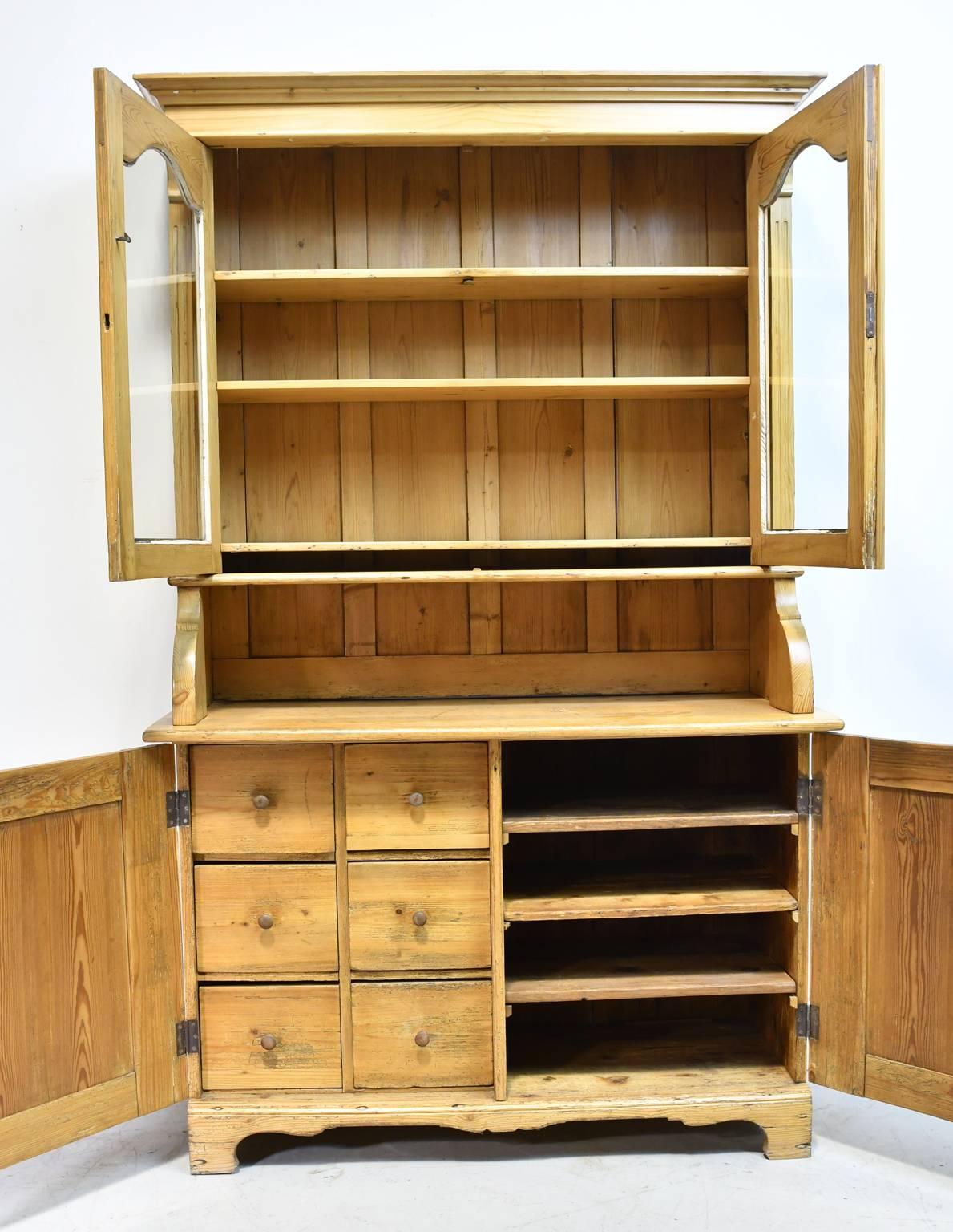 Exceptional North German honey pine hutch or buffet with original glass, a flight of 6 drawers in the bottom cabinet (left) and shelves on the right. All original including hardware with working locks and key. Perfect for your kitchen or informal