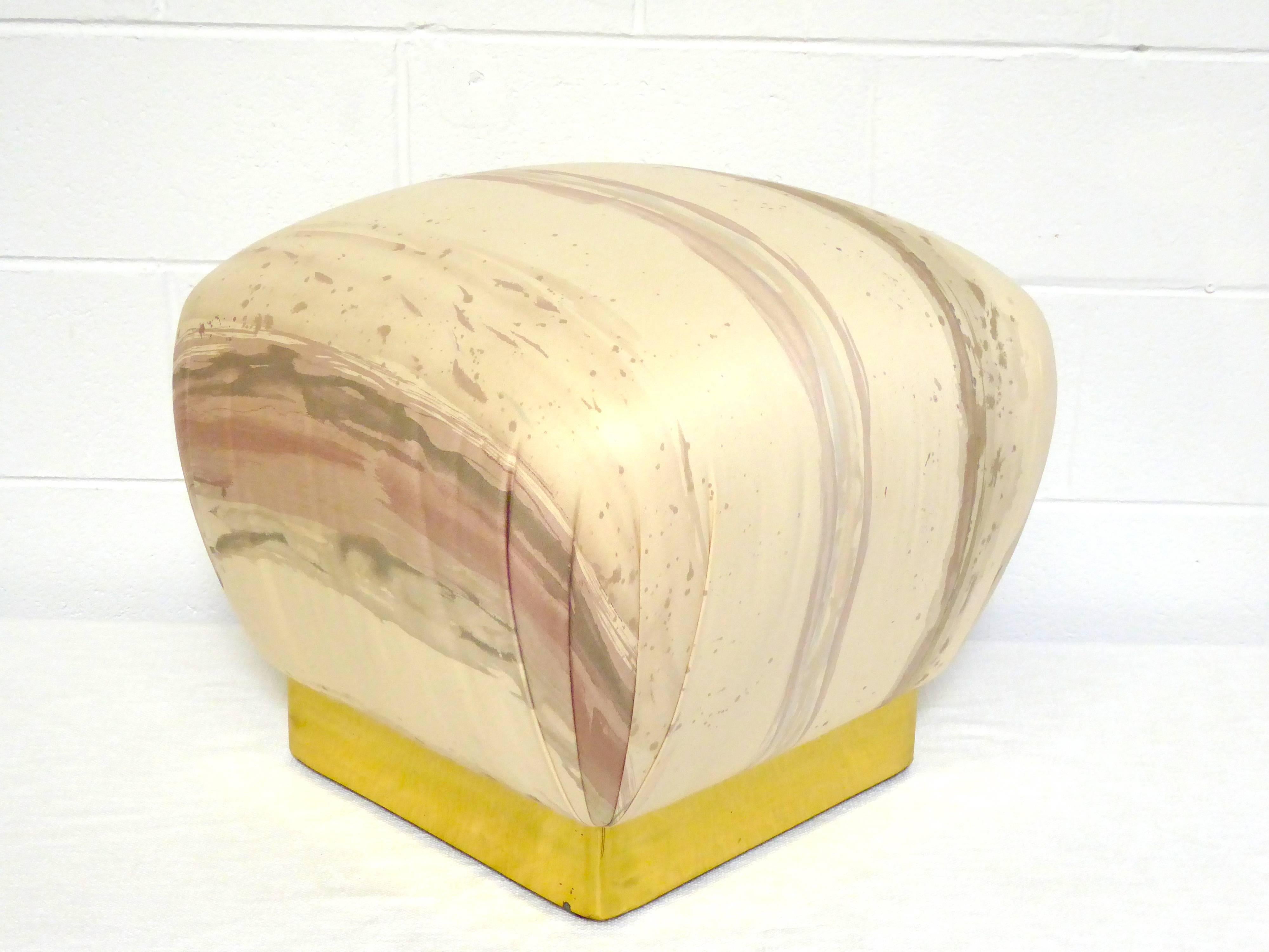 Beautiful upholstered pouf ottoman designed by Marge Carson in the manner of Karl Springer. Original watermarked splatter fabric and brass banded base.