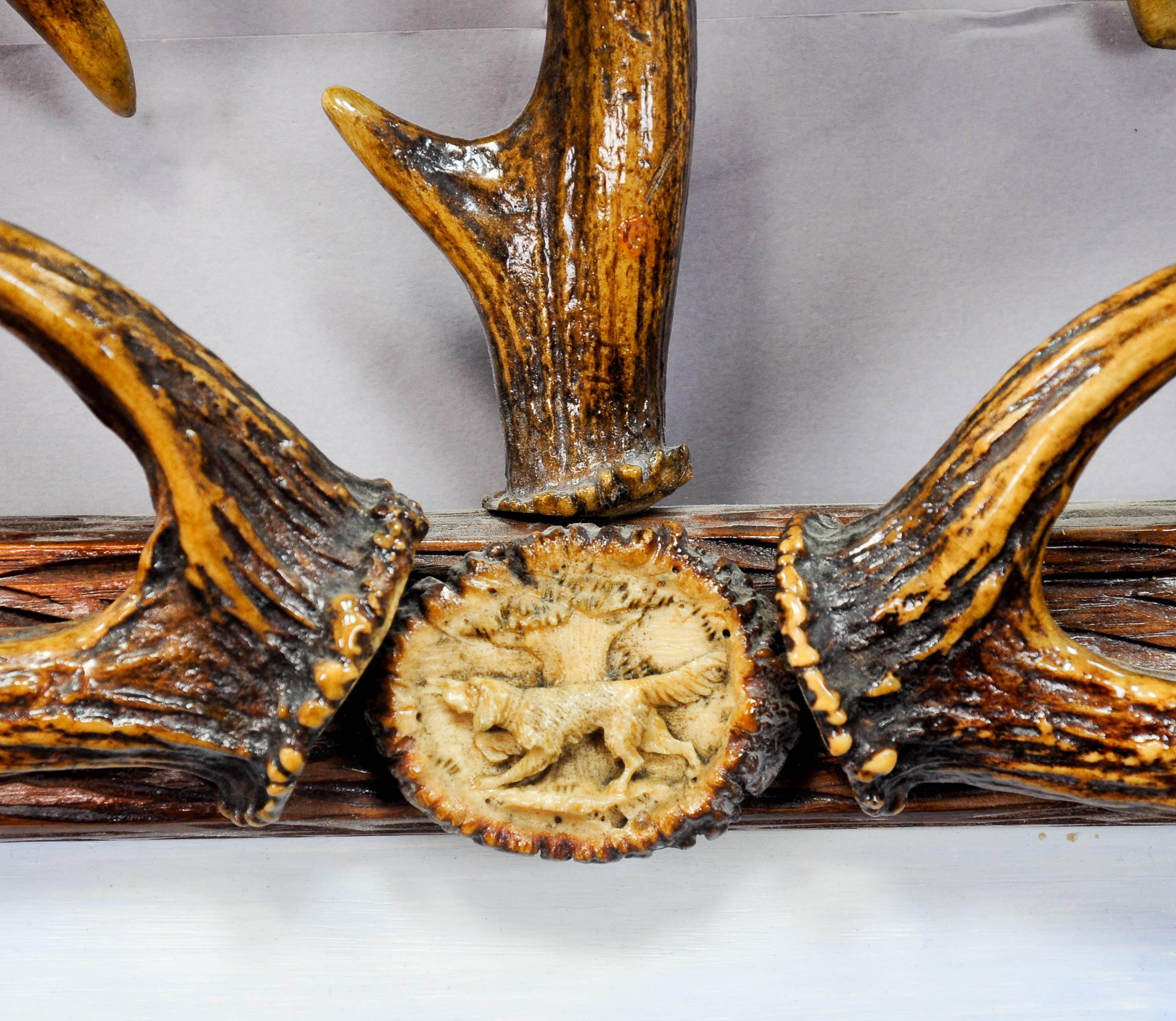 A lovely antler mirror, decorated with carved and turned horn roses and antler pieces of the fallow deer and deer. Surface with lacquered finish. Inside a naive oil painting of an alpine scenery on cardboard which was added later, Germany, circa