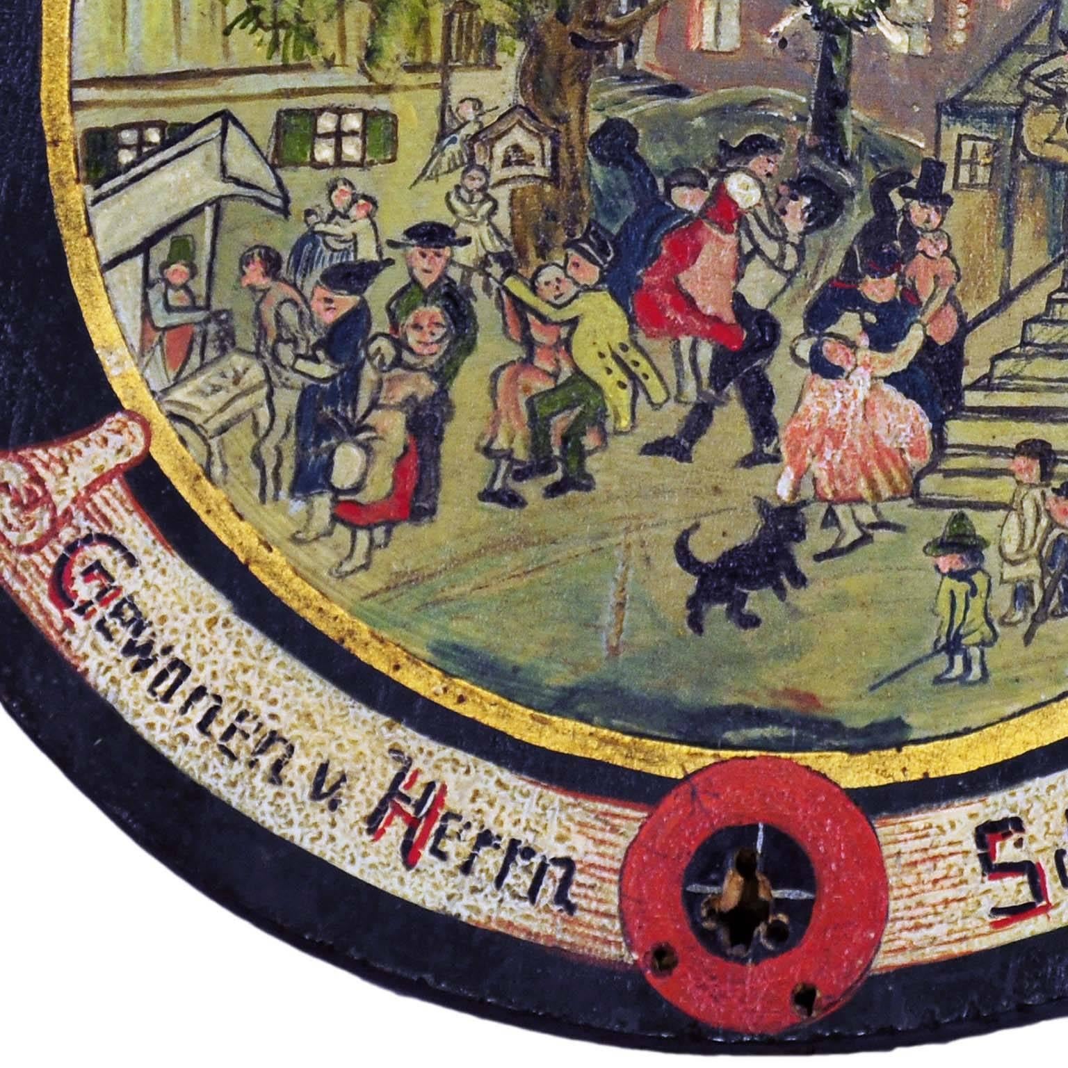A rare hand-painted antique shooting target depicting a folksy village live scene. Oil on wood, hand-painted in naive painting style, Bavaria, circa 1920. On the base with impacts of the shooting, on the back handwritten list of the participants of