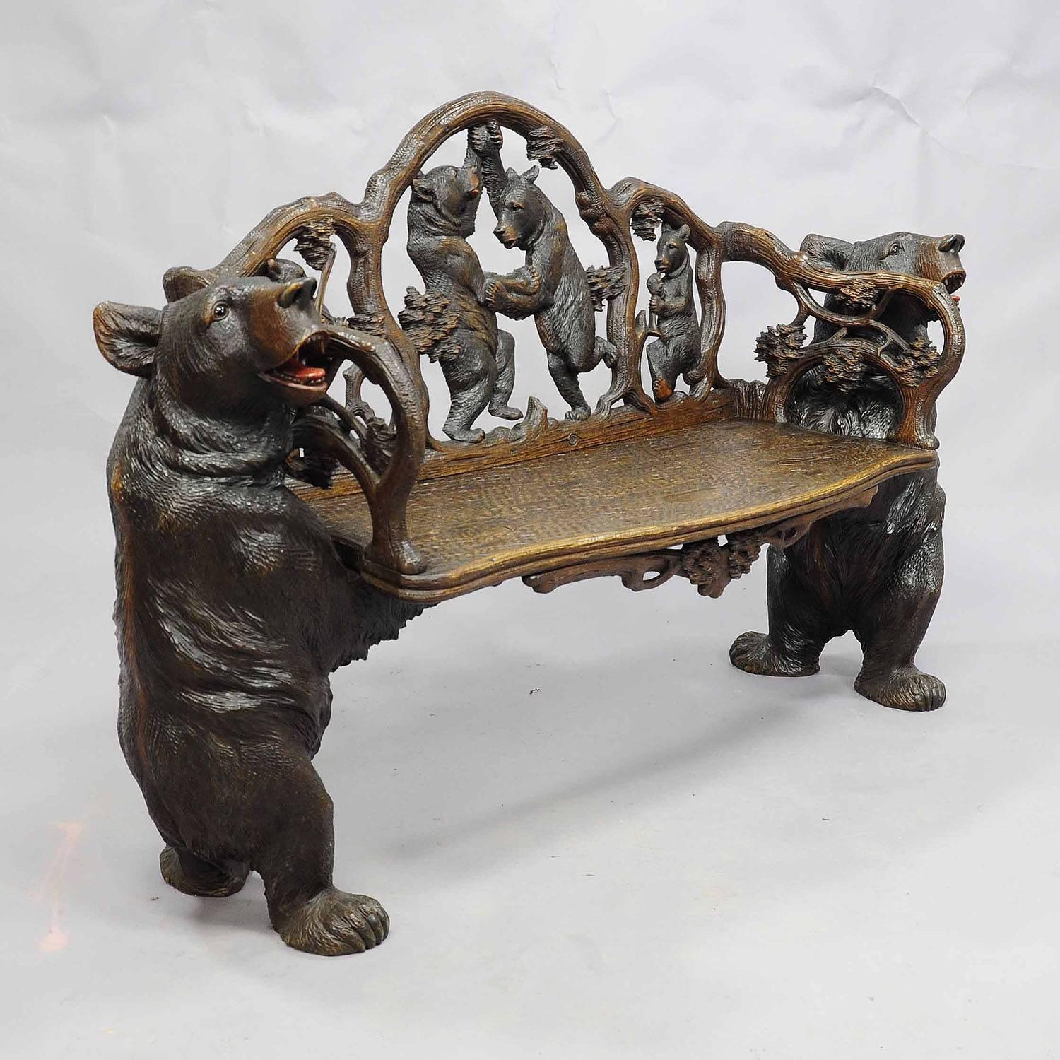 A rare large hand carved linden wood bear bench. With bear musicians and dancing bears on the backrest. Two large bears holding the seat. Executed circa 1900, Swiss Brienz.