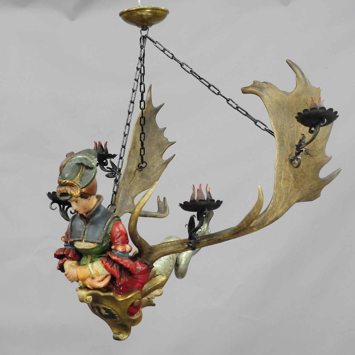 An antique statue of a diana - goddess of the hunt - made of hand-painted plaster - mounted on a pair of original fallow deer antlers. with 4 hand-forged iron candleholders. Manufactured circa 1900. Height figure only circa 14.2