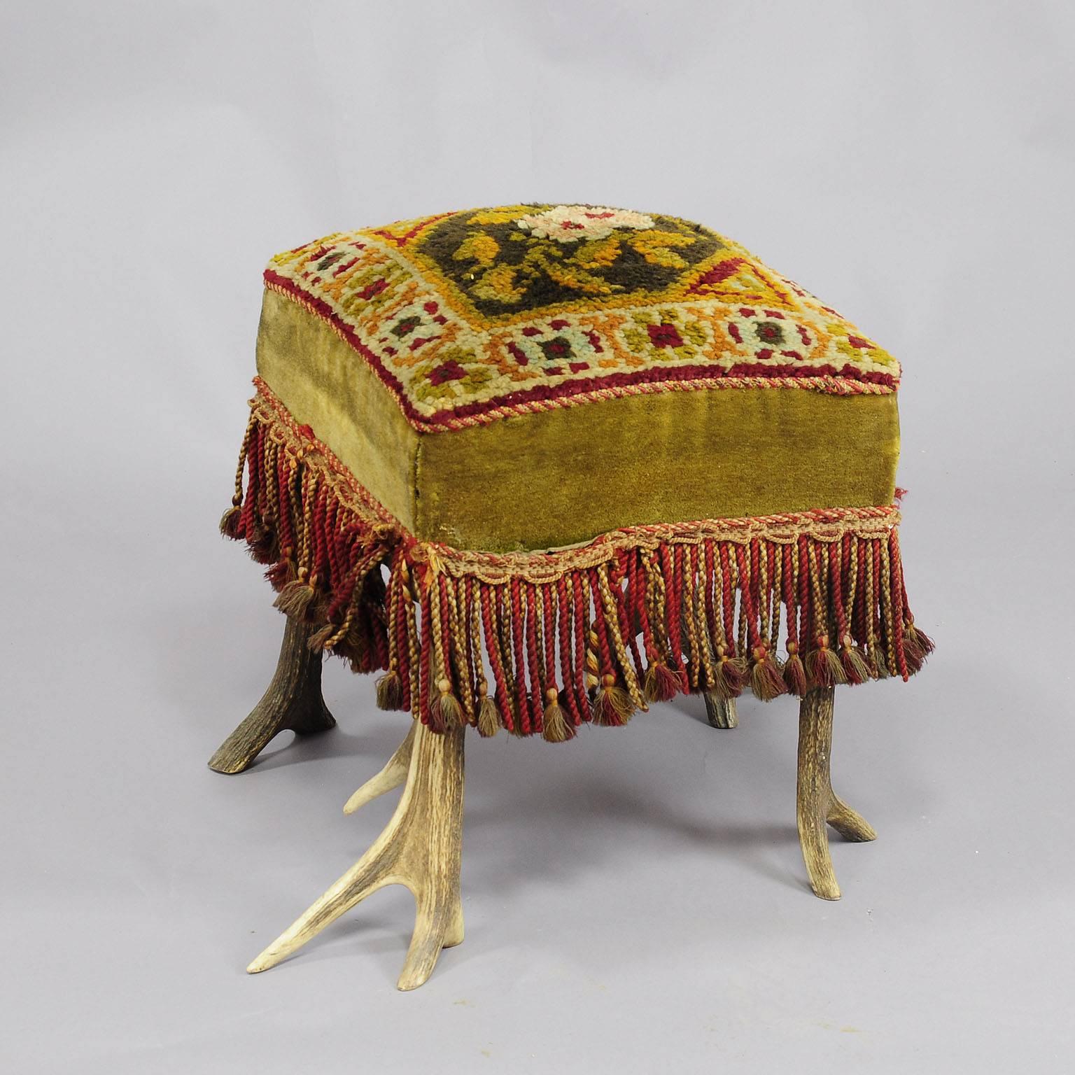 A traditional colorful antler stool with original deer horns as chair legs. The seating surface is hand-woven. Executed, circa 1900.