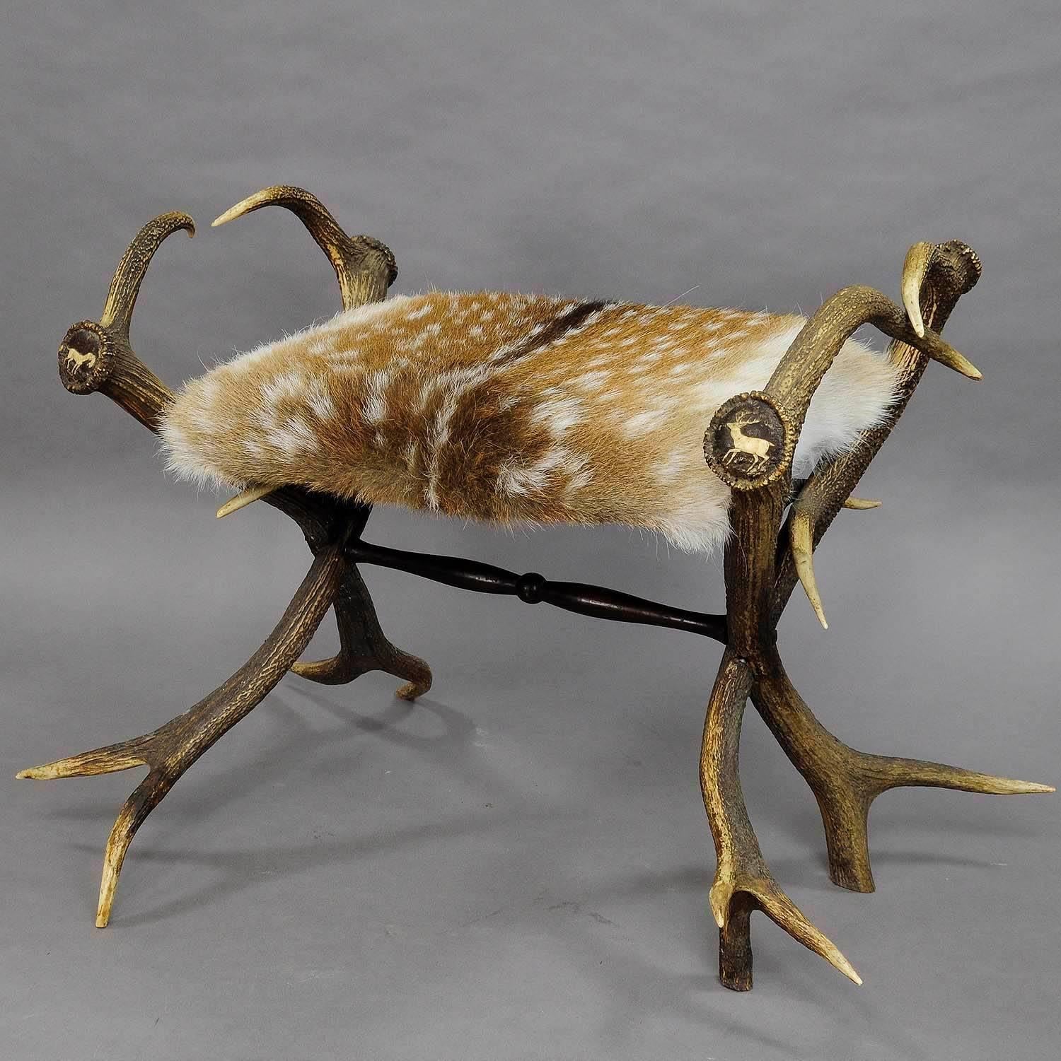 A great antique antler stool with original deer horns as legs. Each ending of the horns with elaborate animal carvings such as deer, fallow deer, stag and stag hound, very good sturdy condition, seat covered with new fallow deer fur. Executed in