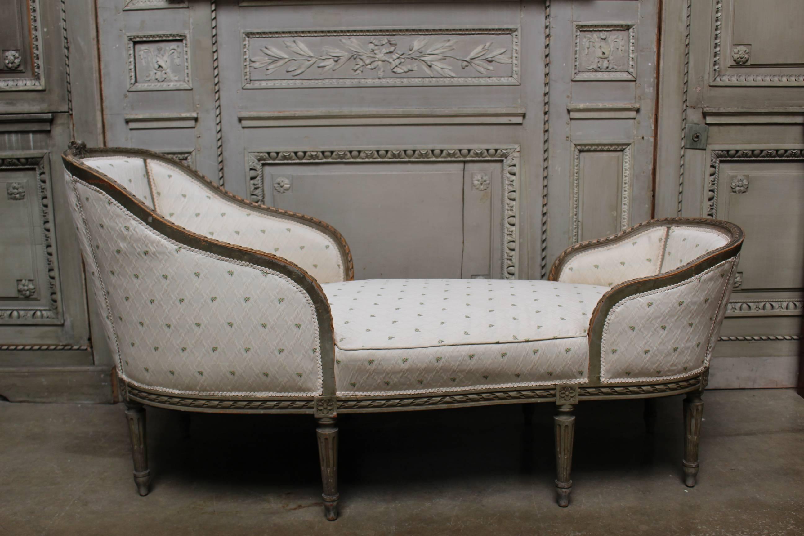 French Louis XVI style chaise lounge from the late 19th century with a French gray painted finish.
This chaise lounge is a wonderful small scale and is comfortable to use. It is beautifully carved with gadrooning, fluted legs and flowers in a