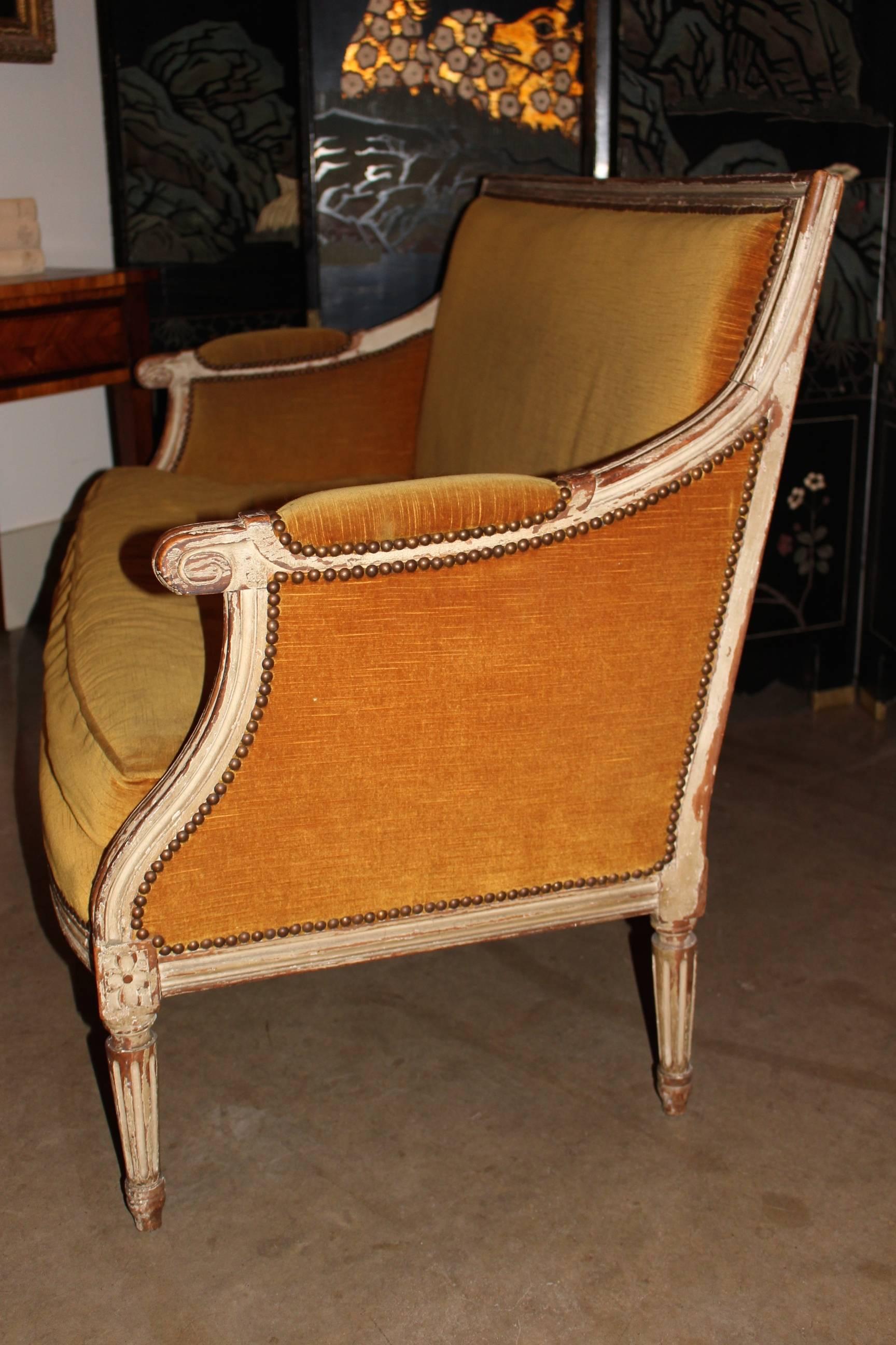 A French Louis XVI style small sofa with an old painted finish.