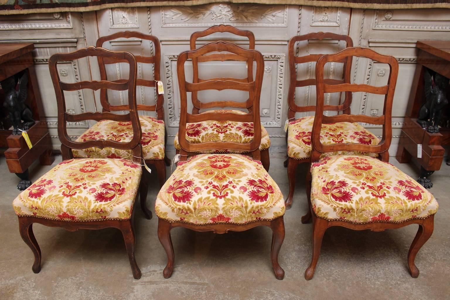A set of six Swiss walnut dining chairs in the Louis XV style.