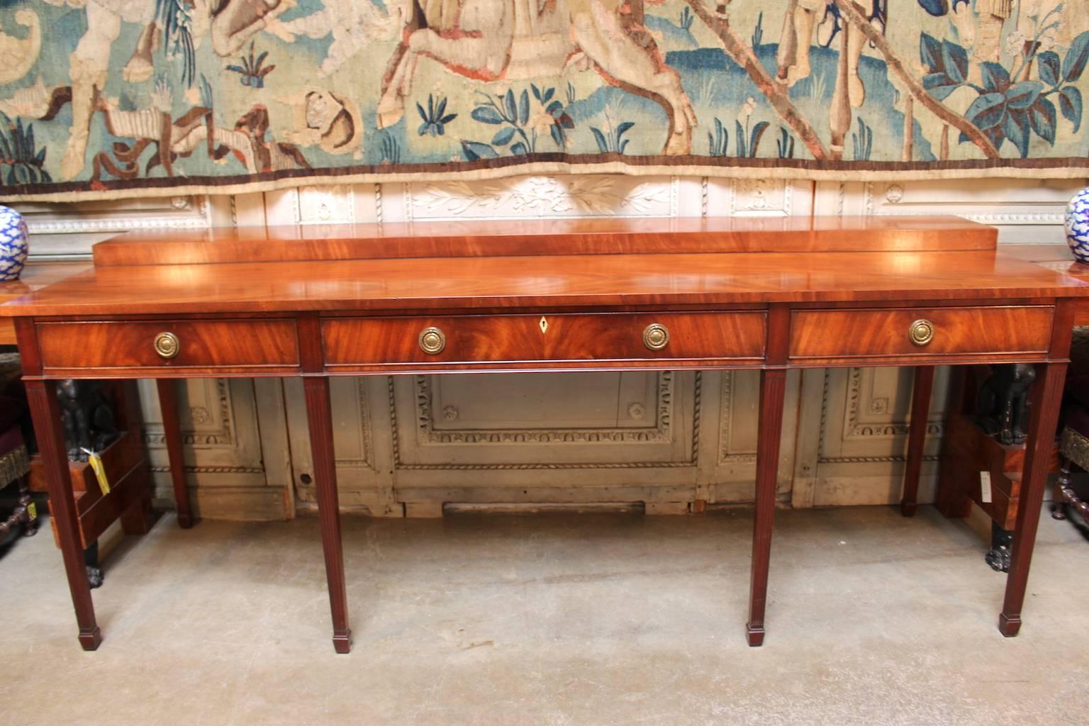 A very large English Hepplewhite style sideboard with three drawers and a two-tiered top.