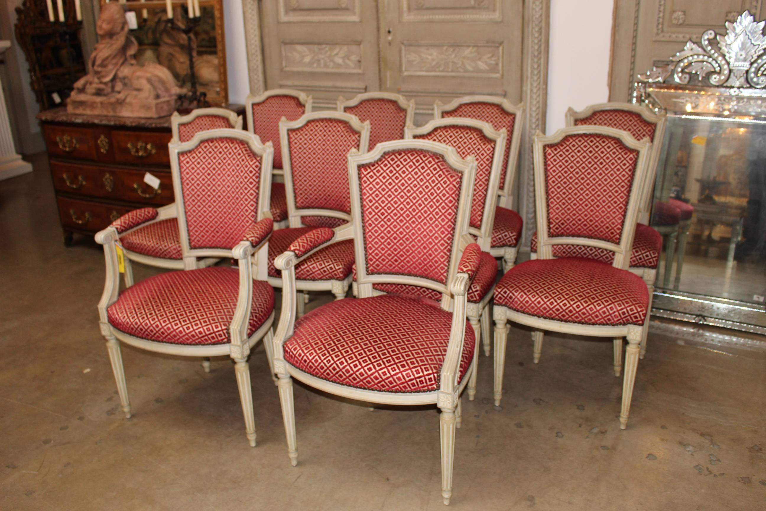 A set of ten French Louis XVI style dining chairs, eight side chairs and two armchairs, with a painted cream and gray finish.