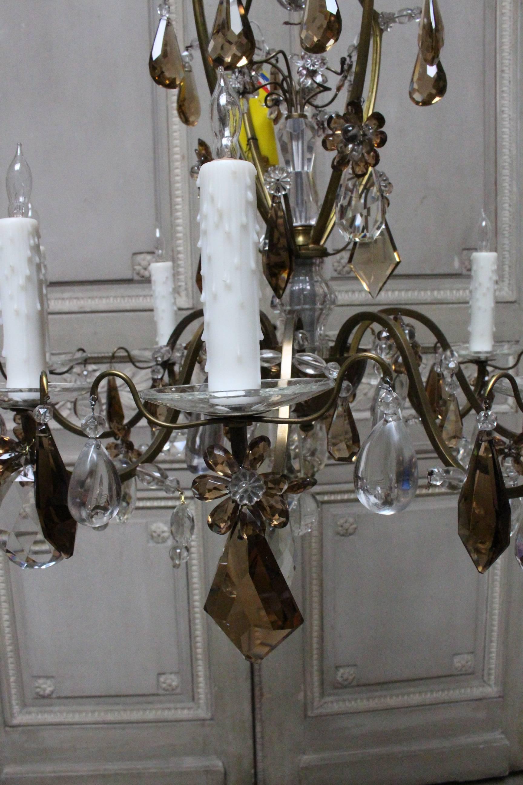 A bronze and crystal chandelier with four matching sconces in the style of Maison Baguès. 