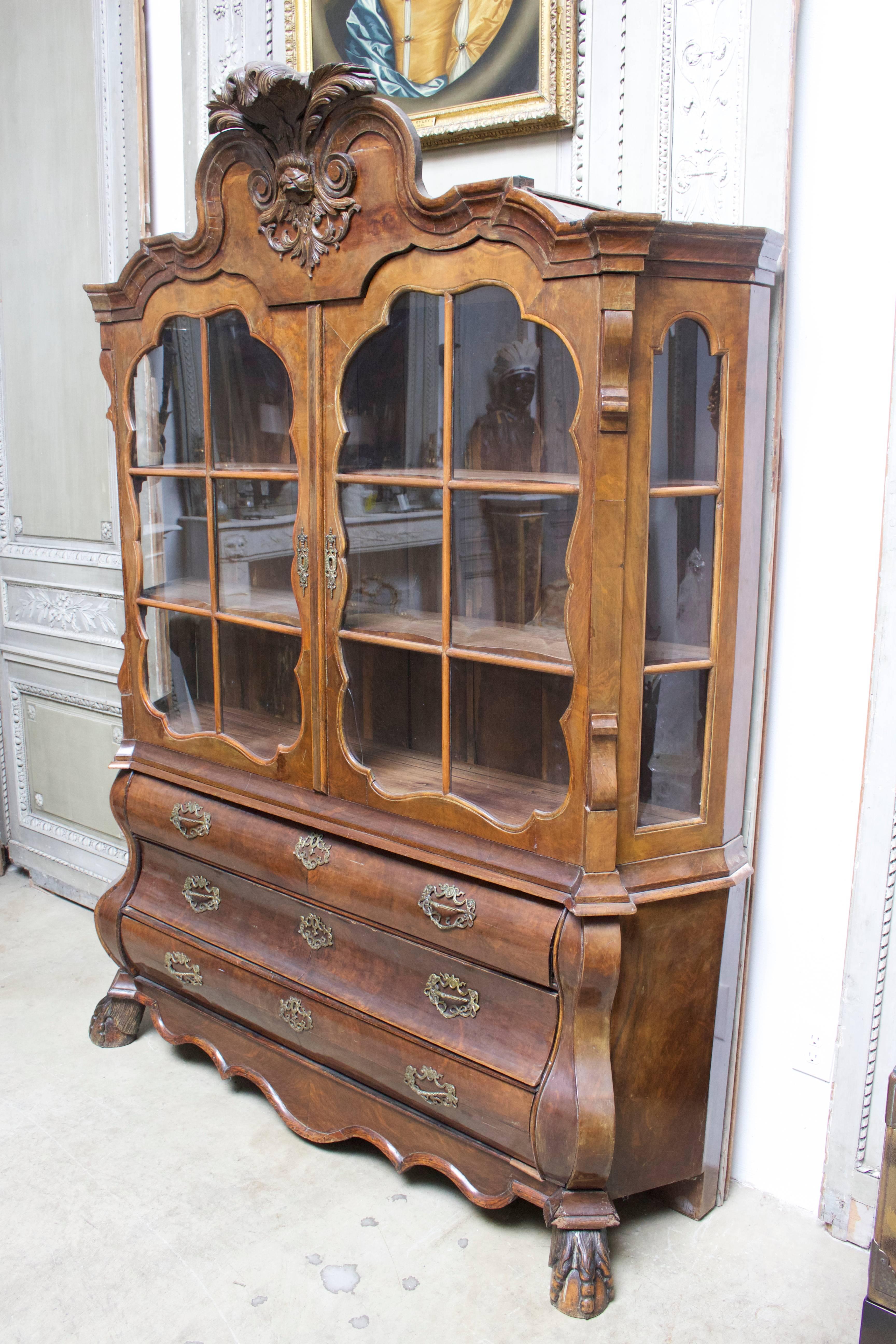 Armadio in noce burlato in stile rococò olandese del XIX secolo con un bell'intaglio e una buona patina. Questa vetrina con ante e lati in vetro poggia su una cassettiera a tre cassetti.