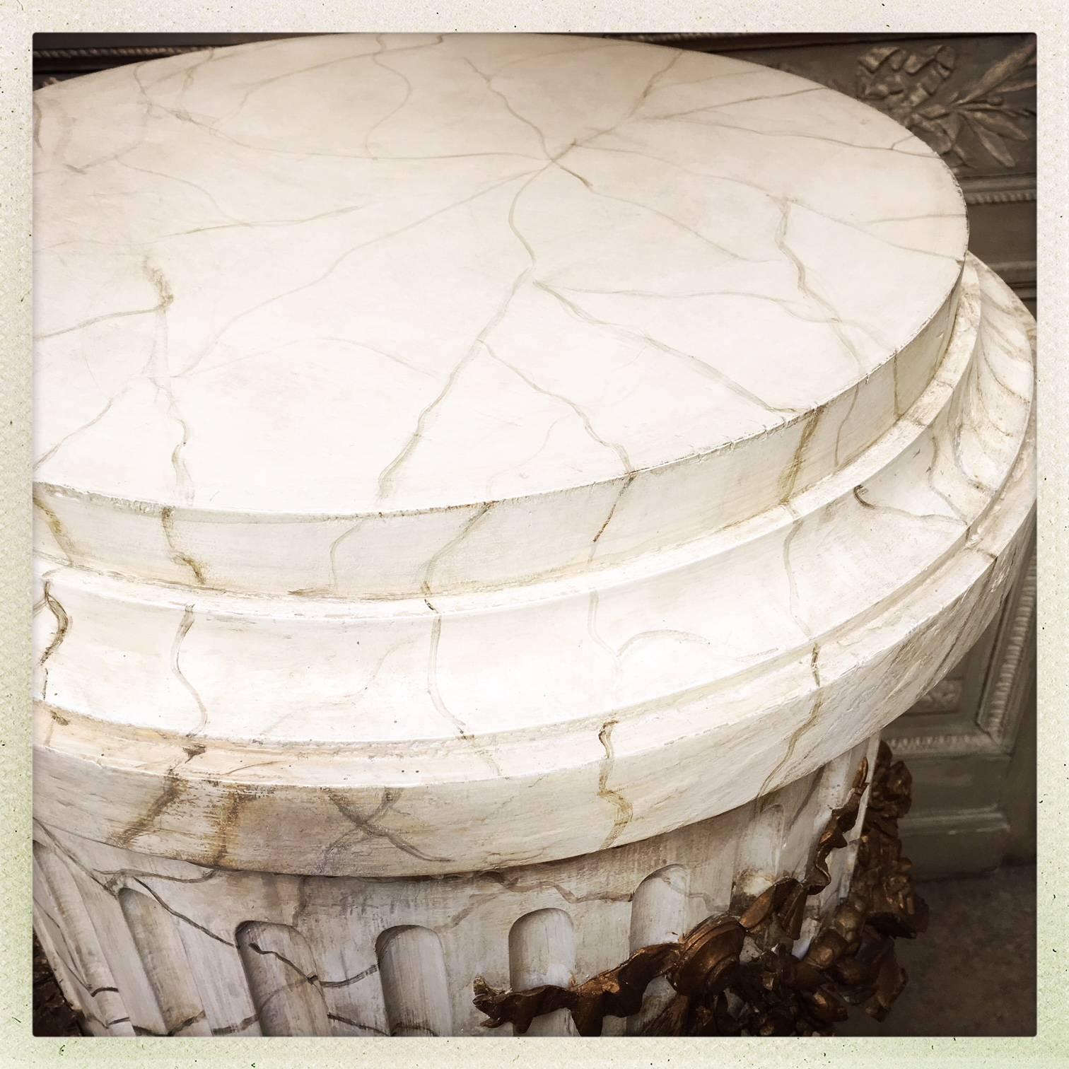 A large French Louis XVI style carved wood pedestal with a faux marble and gilded finish. This is a very decorative piece that can hold a large vessel or bust.