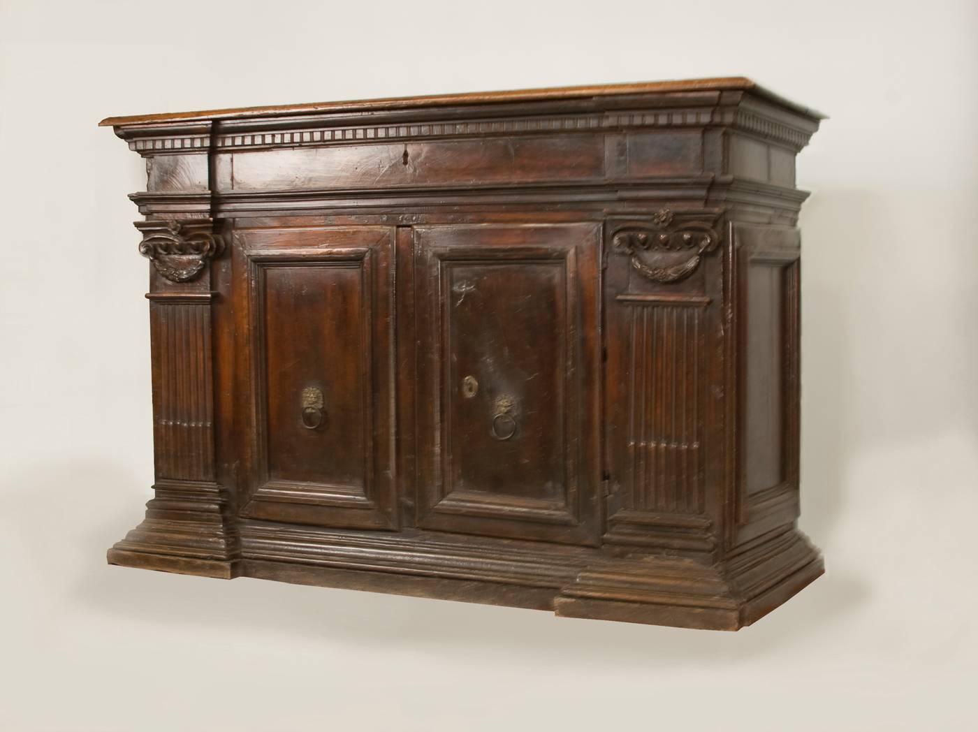 A wonderful  and rare walnut credenza or sideboard, heavy patinated, original
unrestored finish and original hardware. The hand-carved moldings and classic.
Ionic swags above fluted pilasters which rest on a heavy base molding are
typical for this
