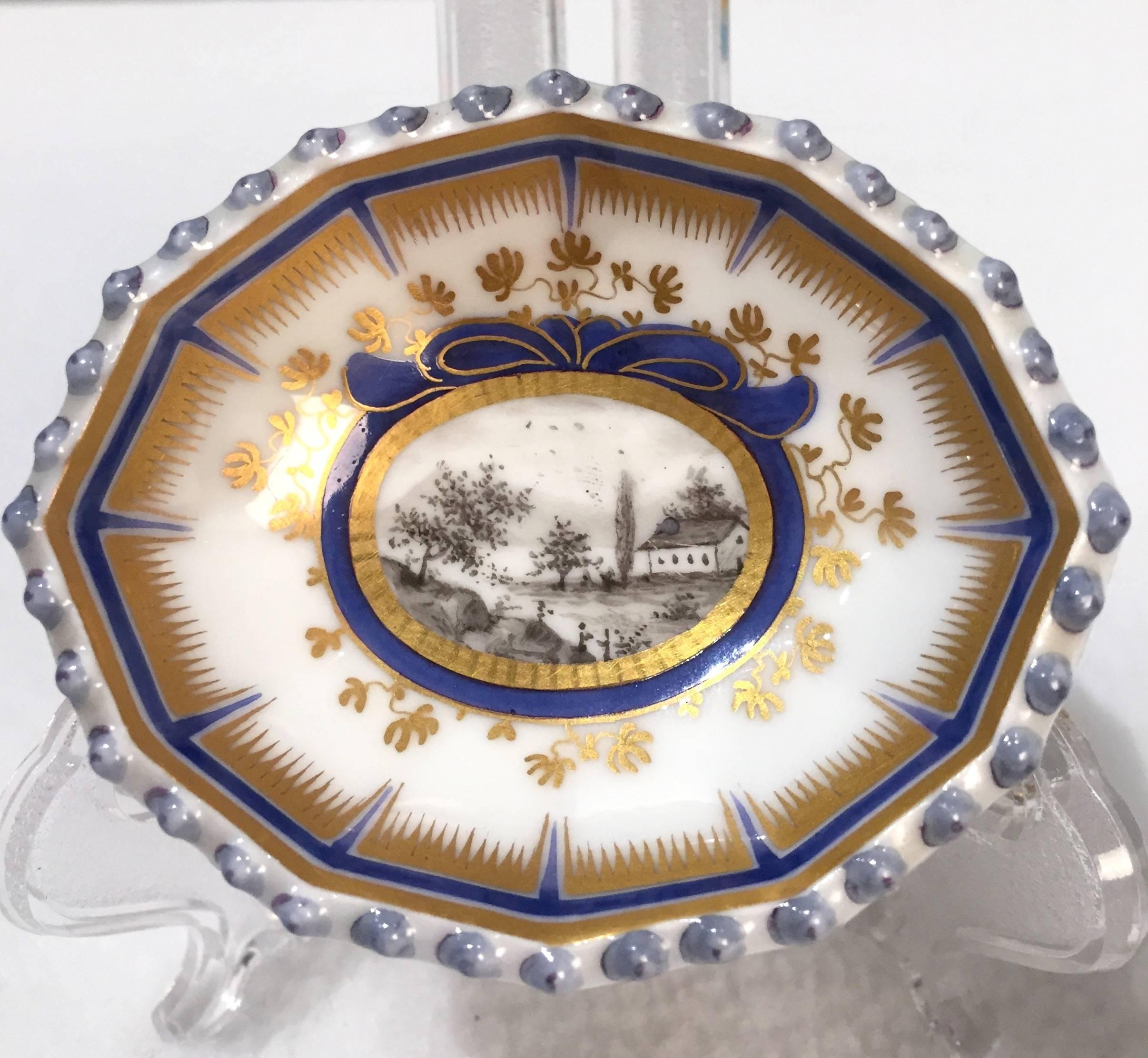 This pair of Master Salt Cellars has the blue under glaze mark of Nymphenburg.
The scenic landscape is hand painted with great detail and skill. The painted
cartouche is surrounded with a cobalt blue and gold leaf ribbon detail.
The reticulated