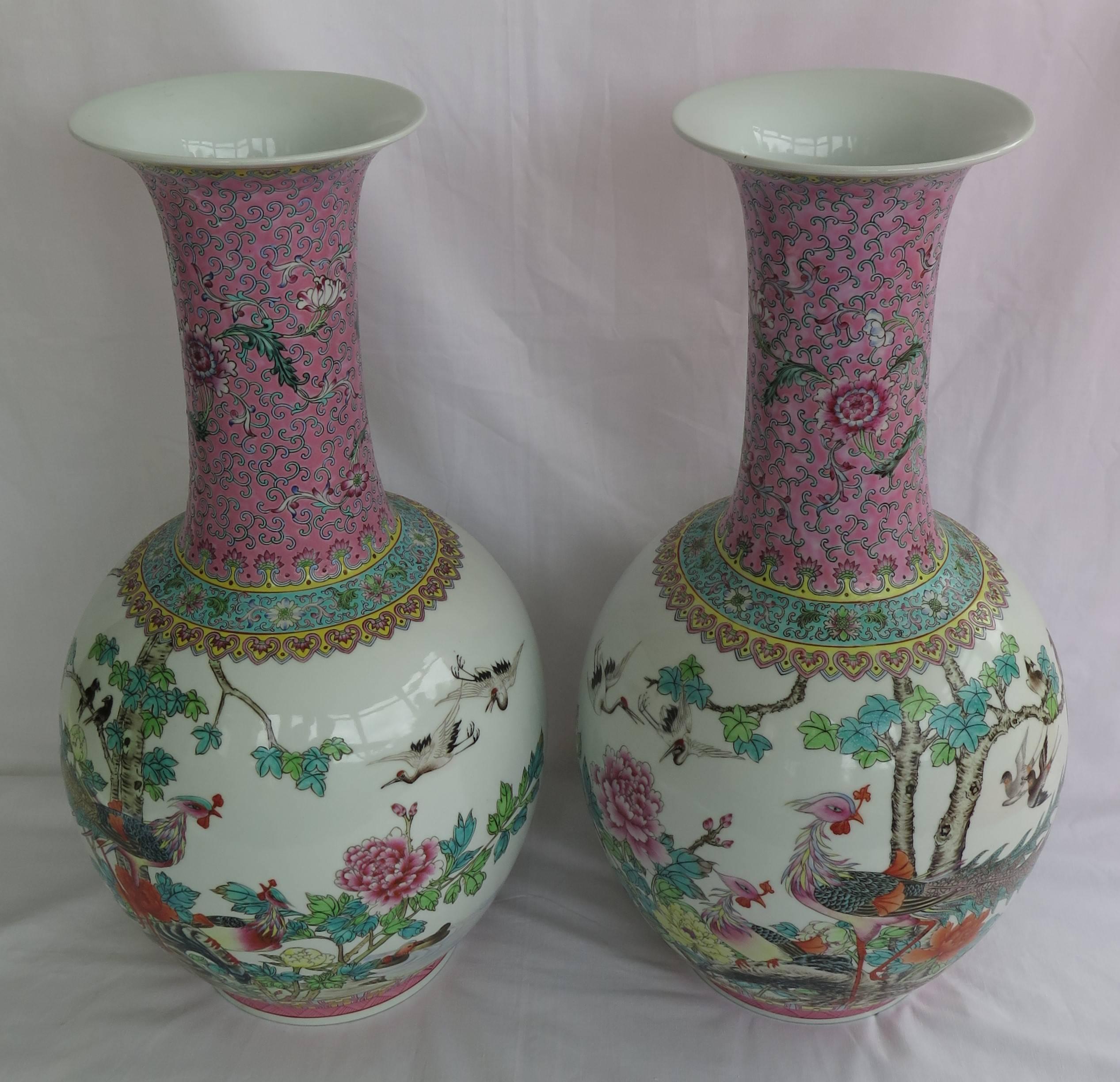 These are a very decorative and beautifully hand painted pair of Chinese Export porcelain vases dating to the mid-20th century.

Each vase has an ovoid bottle form leading to a slender neck with a flared rim, producing a superb elegant shape. 
