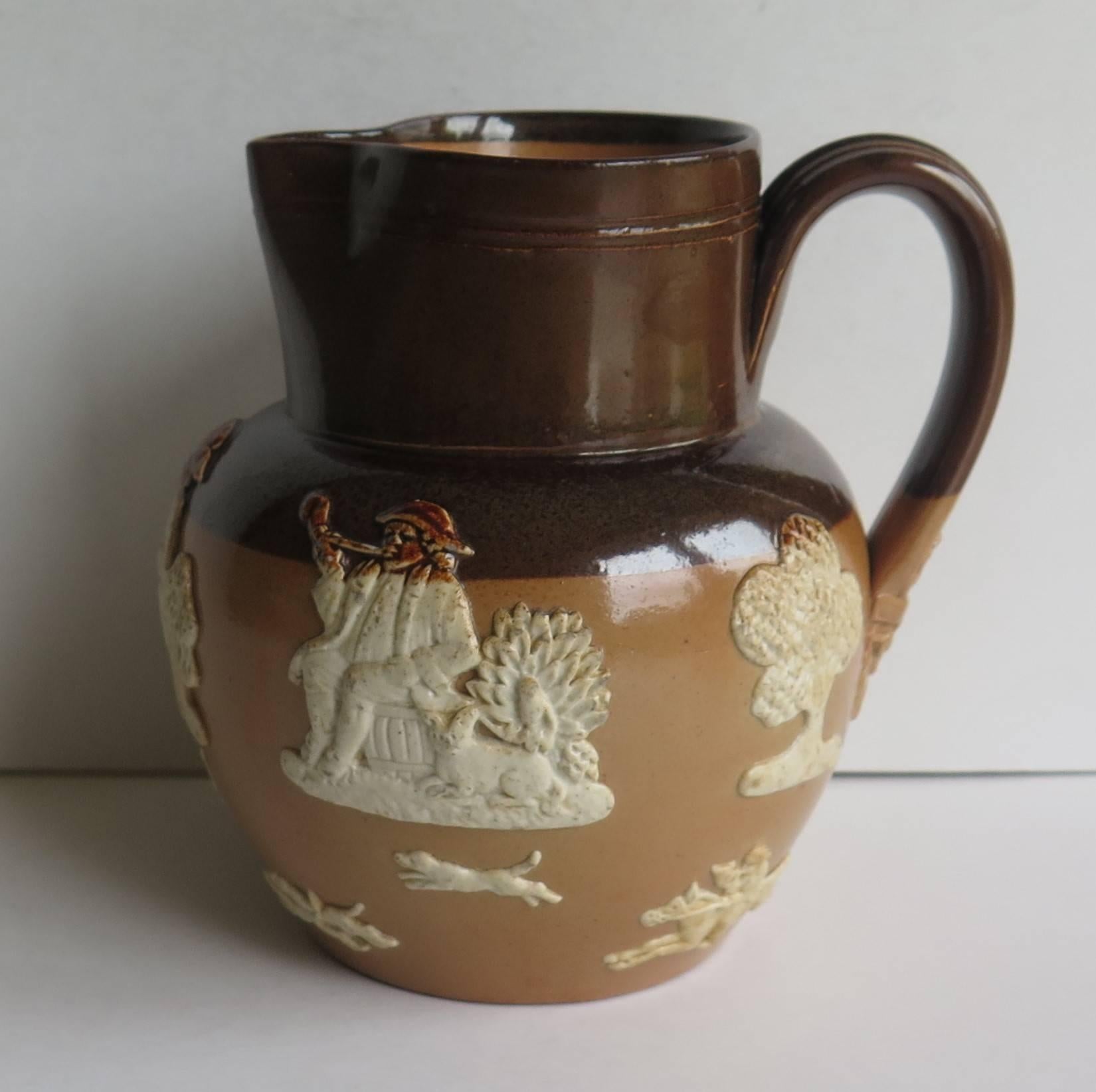 This is a good stoneware jug or pitcher made by The Royal Doulton, Lambeth, London factory, very early in the 20th century, in the Edwardian period.

The jug has a moulded shape with nice ribbed loop handle. It is from Doultons Hunting ware