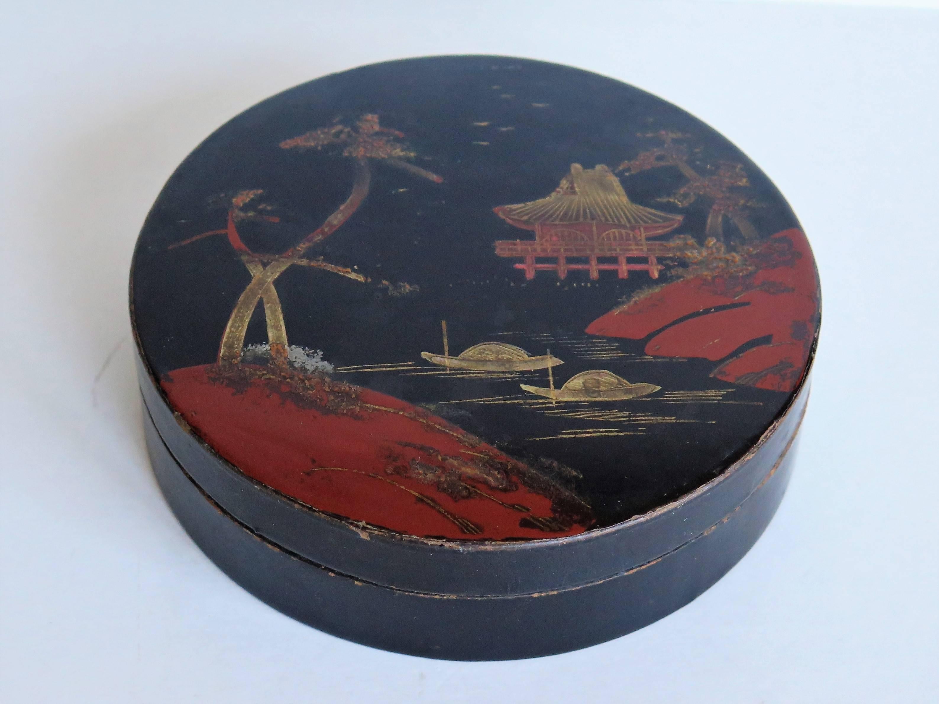 This is a beautiful papier mâché, circular lacquered lidded box, which we attribute to being made in Japan during the early 20th century, circa 1910.

This is a very decorative box with a delicately hand-painted waterside scene of a pagoda or