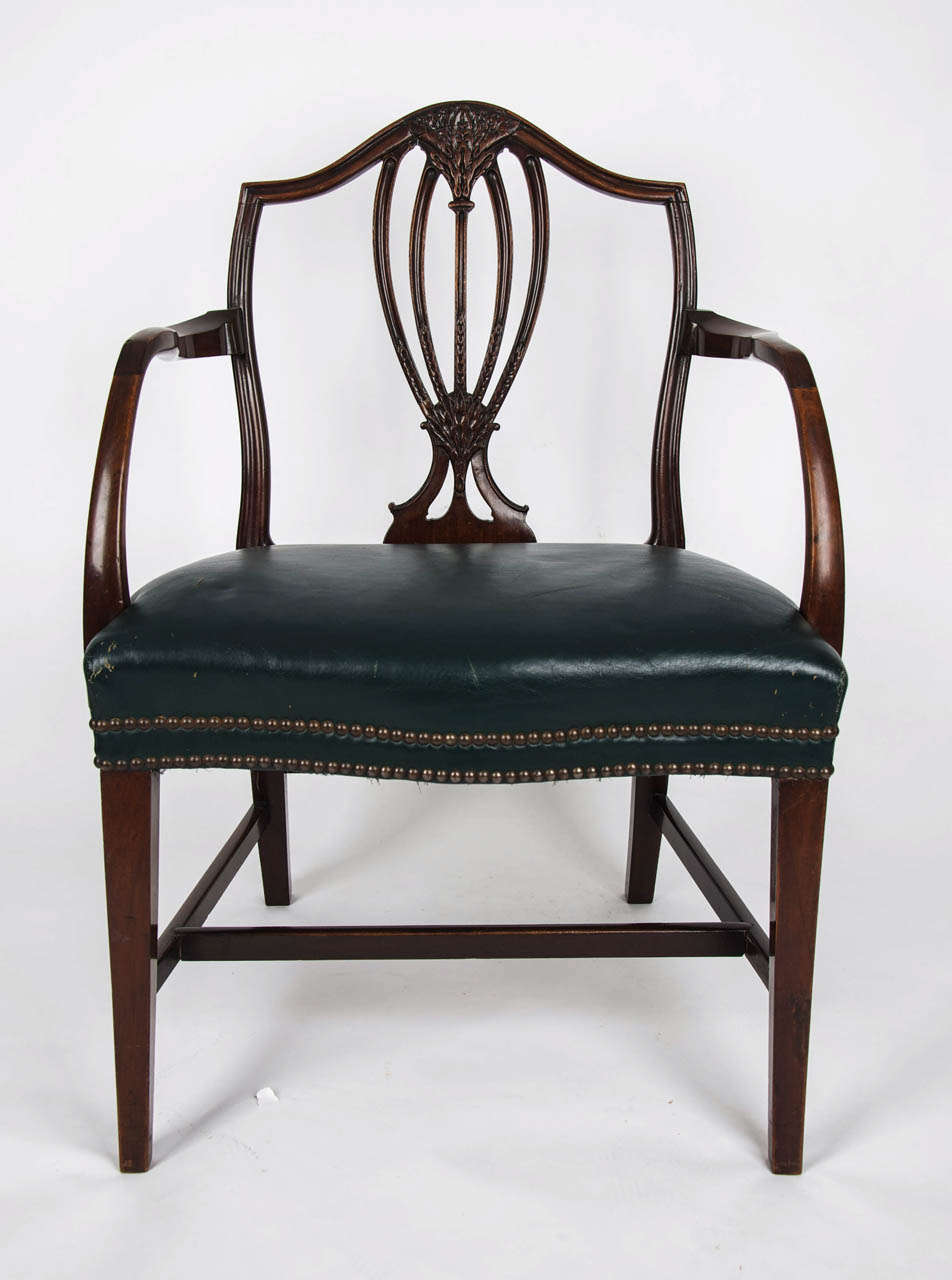 This is a good quality English armchair from the George III, Hepplewhite period, made circa 1785.

The hardwood, possibly red walnut, frame has a camel back with a well carved central vase shaped splat featuring Prince of Wales plumes. The arms are