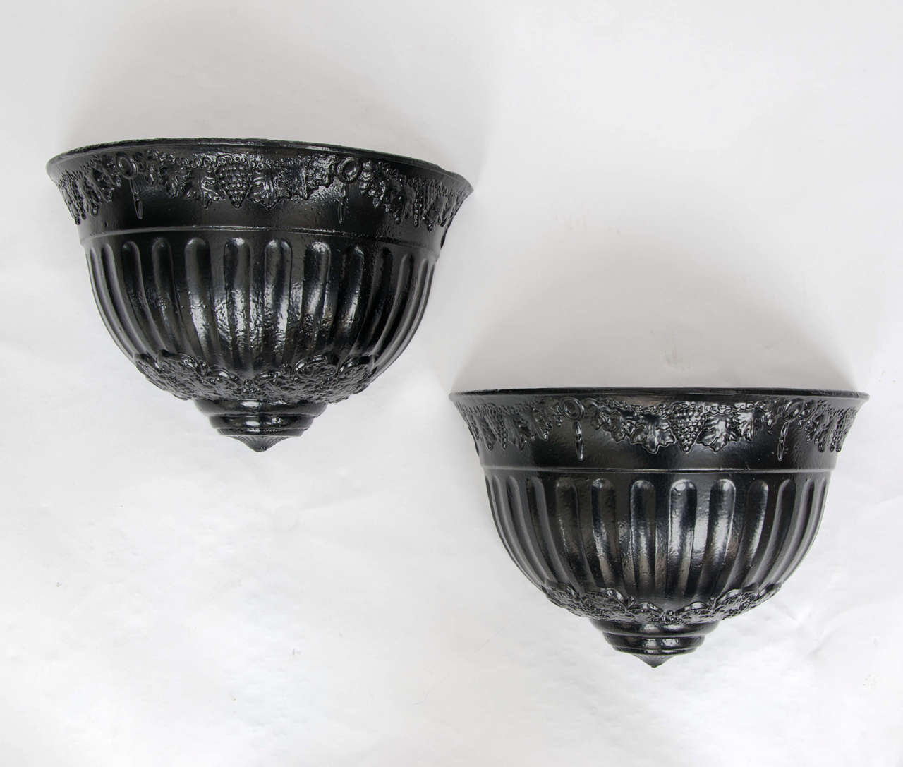 These are a very attractive and original pair of cast iron, wall hanging, English Planters from the Regency period of the early 19th century, circa 1820.

Each planter is semi-circular in profile with vertical fluting in the centre section.
There is