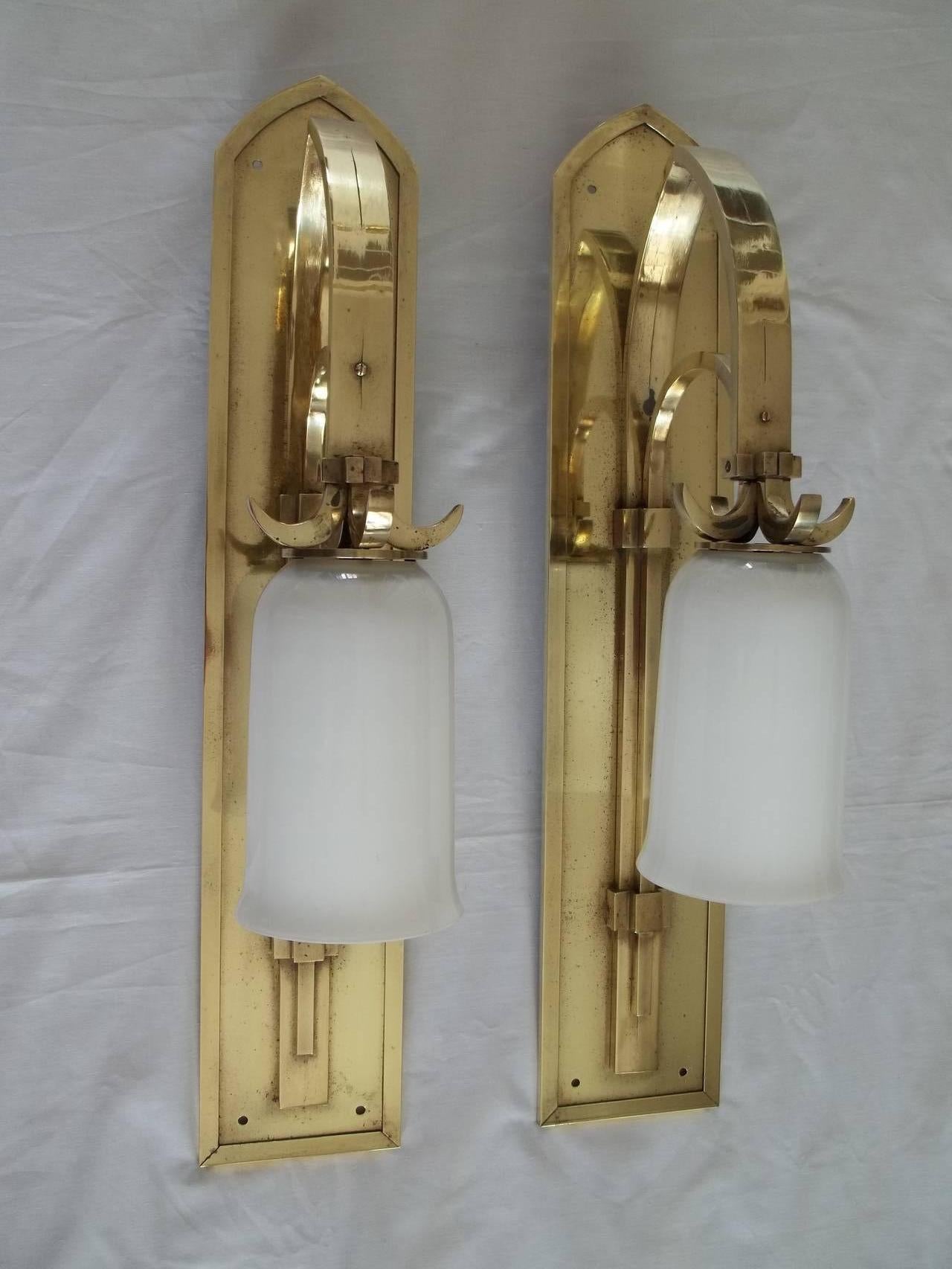 These are a superb PAIR of WALL LAMPs in the Gothic Revival style, circa 1900 to 1910.

These lamps are substantial and very well made in heavy brass.

The lamps are supported by a twin arched frame the upper outer arch having a well defined