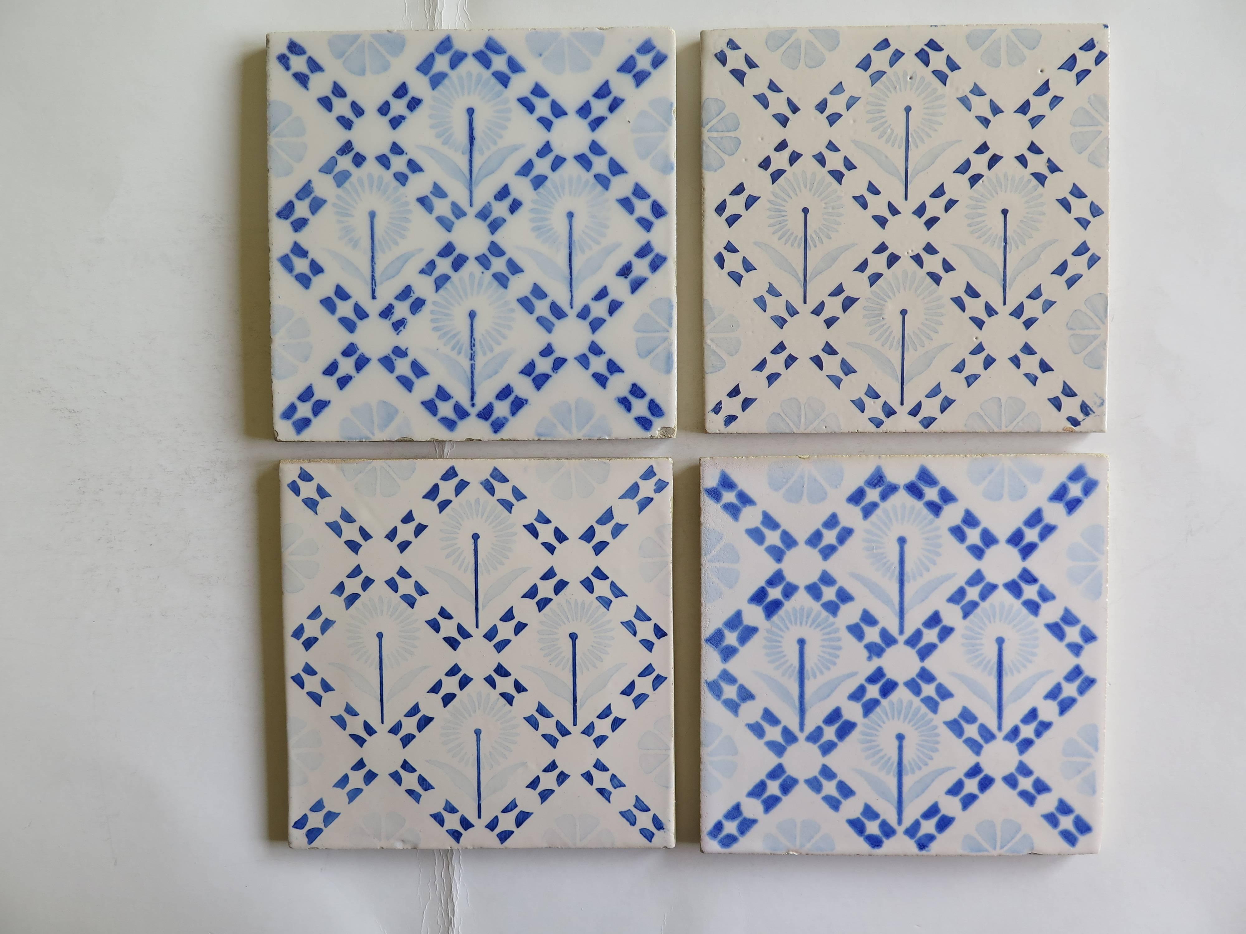 Four glazed earthenware tiles from the Art-Deco period, probably made in the Netherlands, circa 1930.

The tiles have a geometric blue and white pattern with a stylised flower design located within diagonal bordered squares.

All tiles have the