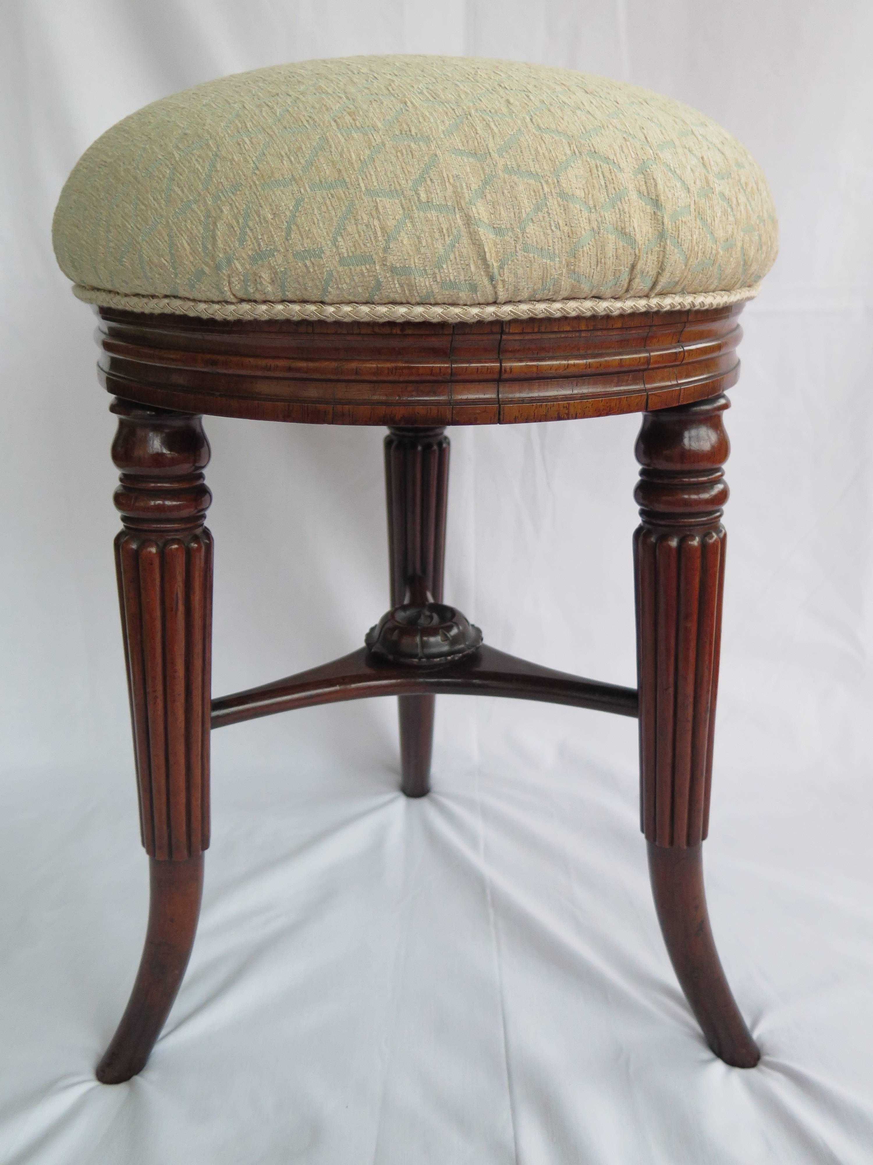 This is an elegant, fine quality STOOL from the English, Early Regency Period, circa 1820, late George 111rd or George 1Vth.

The circular stool is made of solid Rosewood with three reeded tapered legs, outwardly splayed towards the foot.The legs