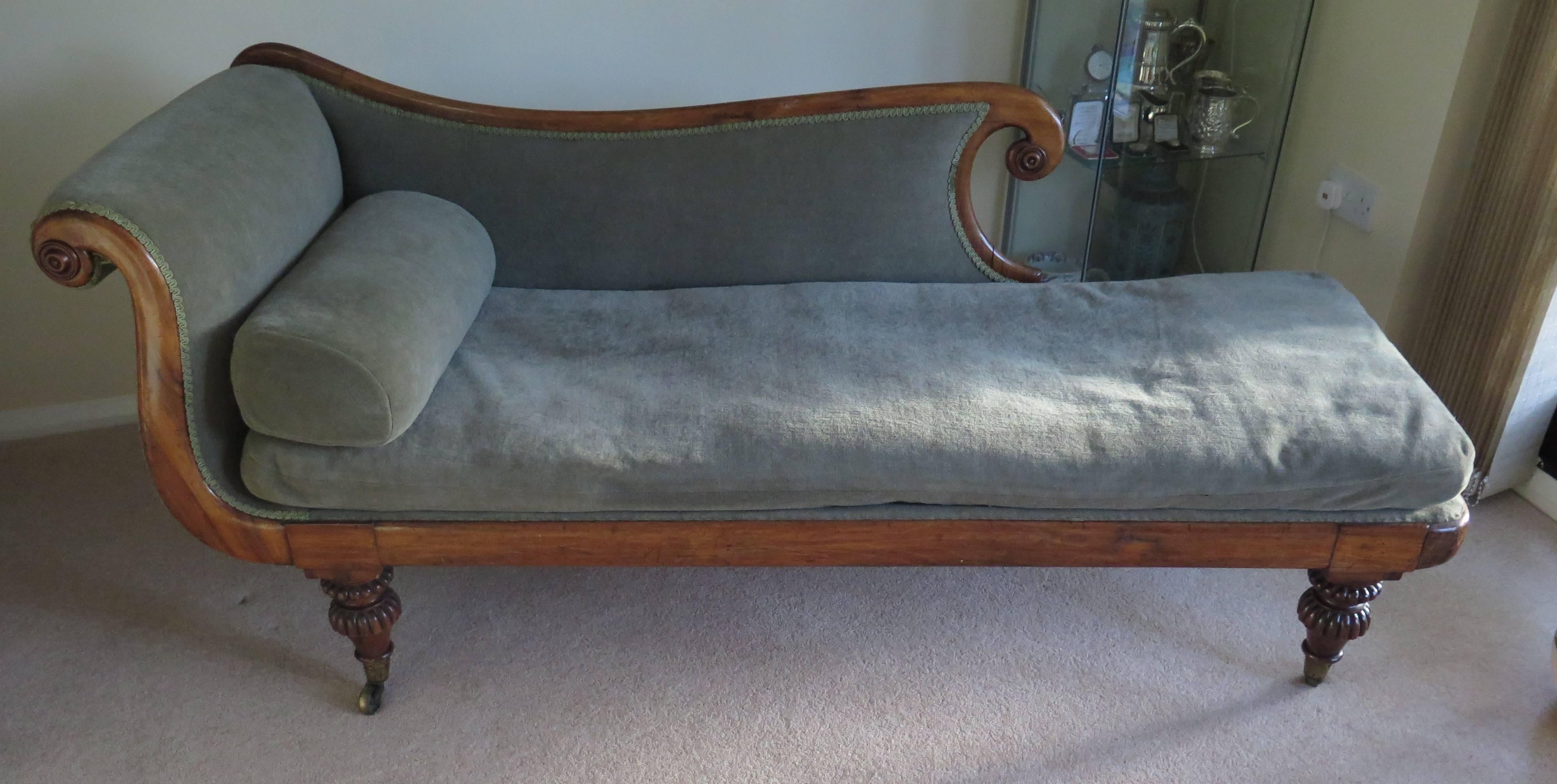 This is a very elegant Chaise Longue or Day Bed.

It is English and from the late Regency Period with a Mahogany frame.

It has a single scroll end with a low sweeping back terminating in a carved scroll, both scrolls having carved roundels. The