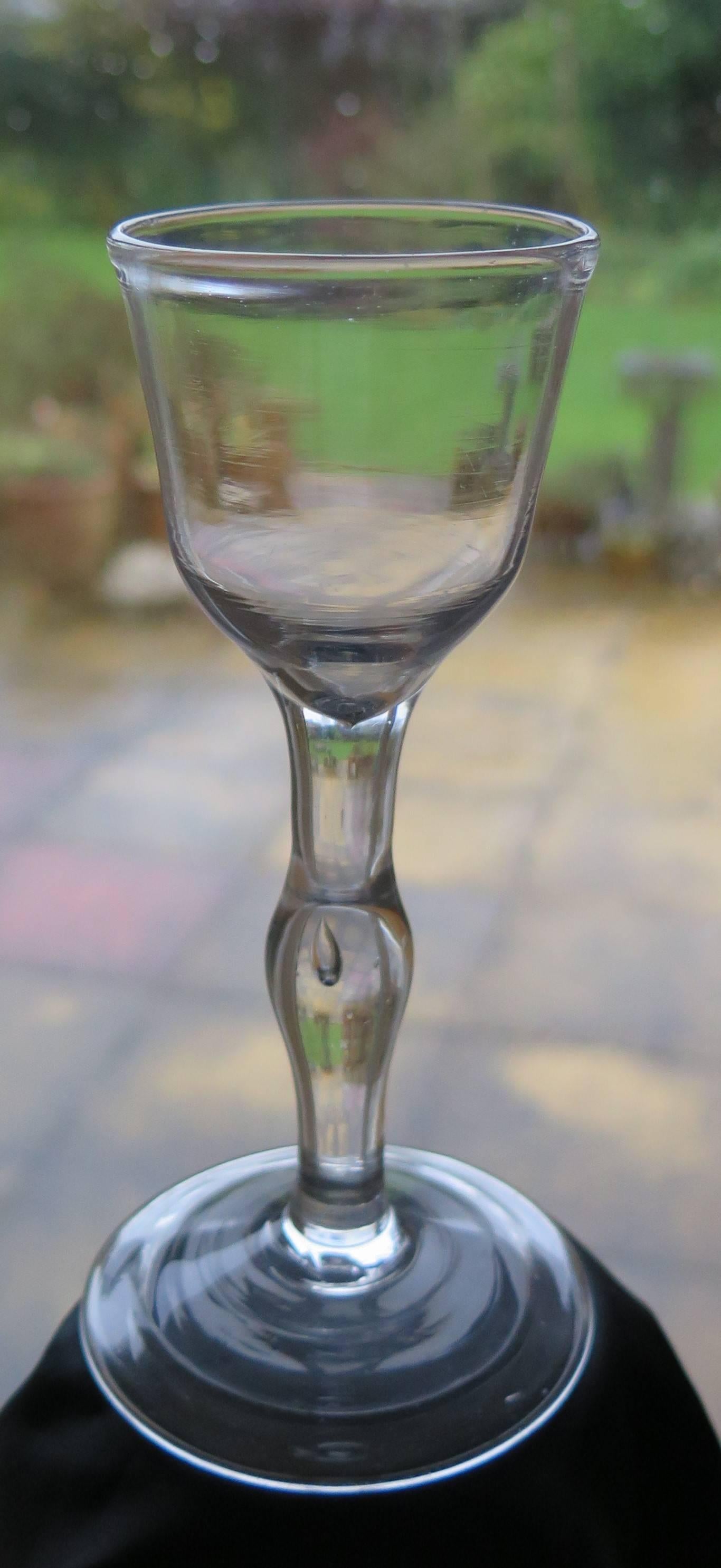 This is a good handblown Wine Drinking Glass;  a Balustroid form with a solid stem having a central knop with a tear, dating from the middle of the 18th century, George 11nd period, circa 1745.

English 18th Century Drinking glasses are very