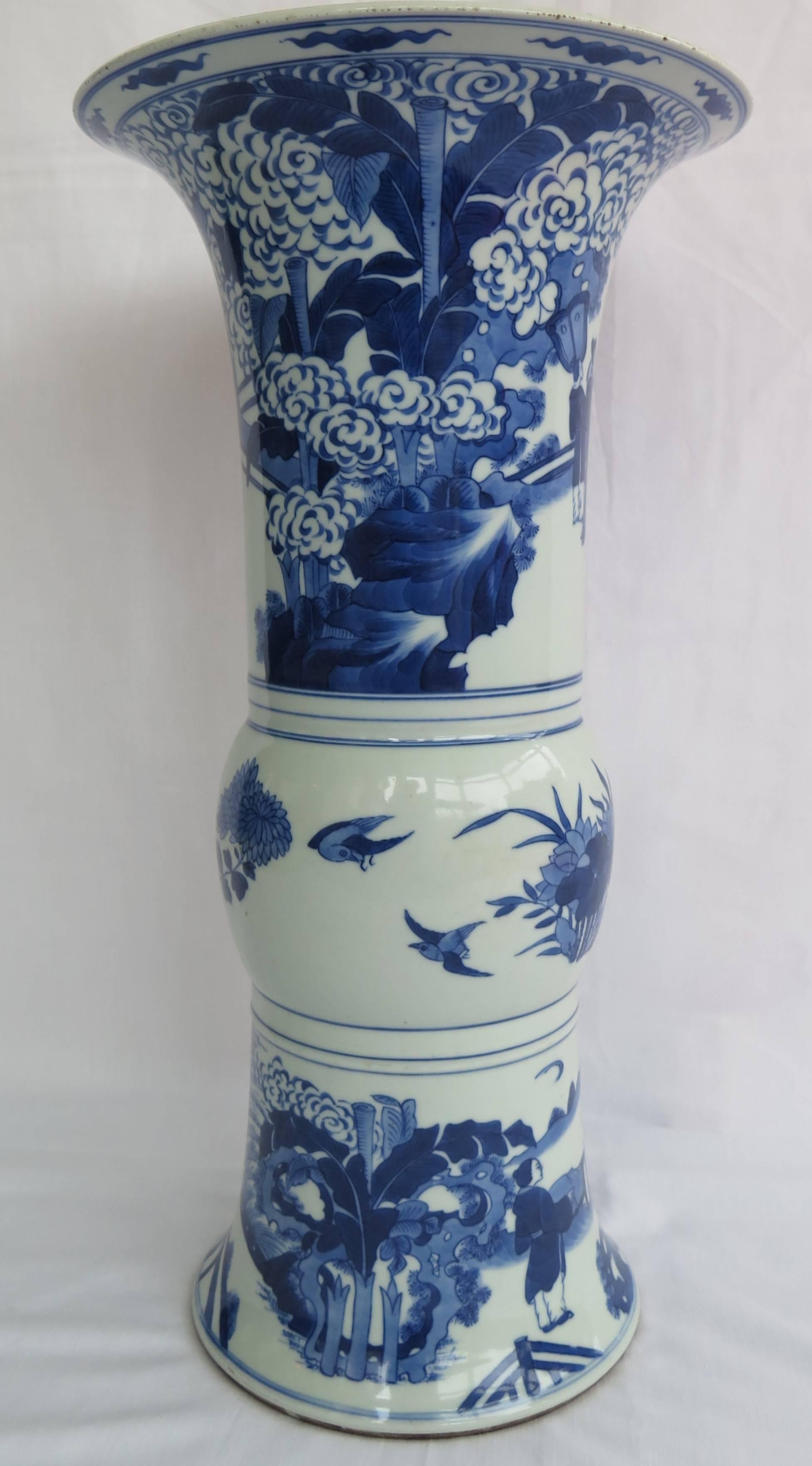 This is a very distinctive, large Chinese blue and white Gu-shaped beaker vase. The base has a painted double circle mark as used in the Kangxi period of the early 18th century but we date this vase to the early 19th century. 
 
This vase is