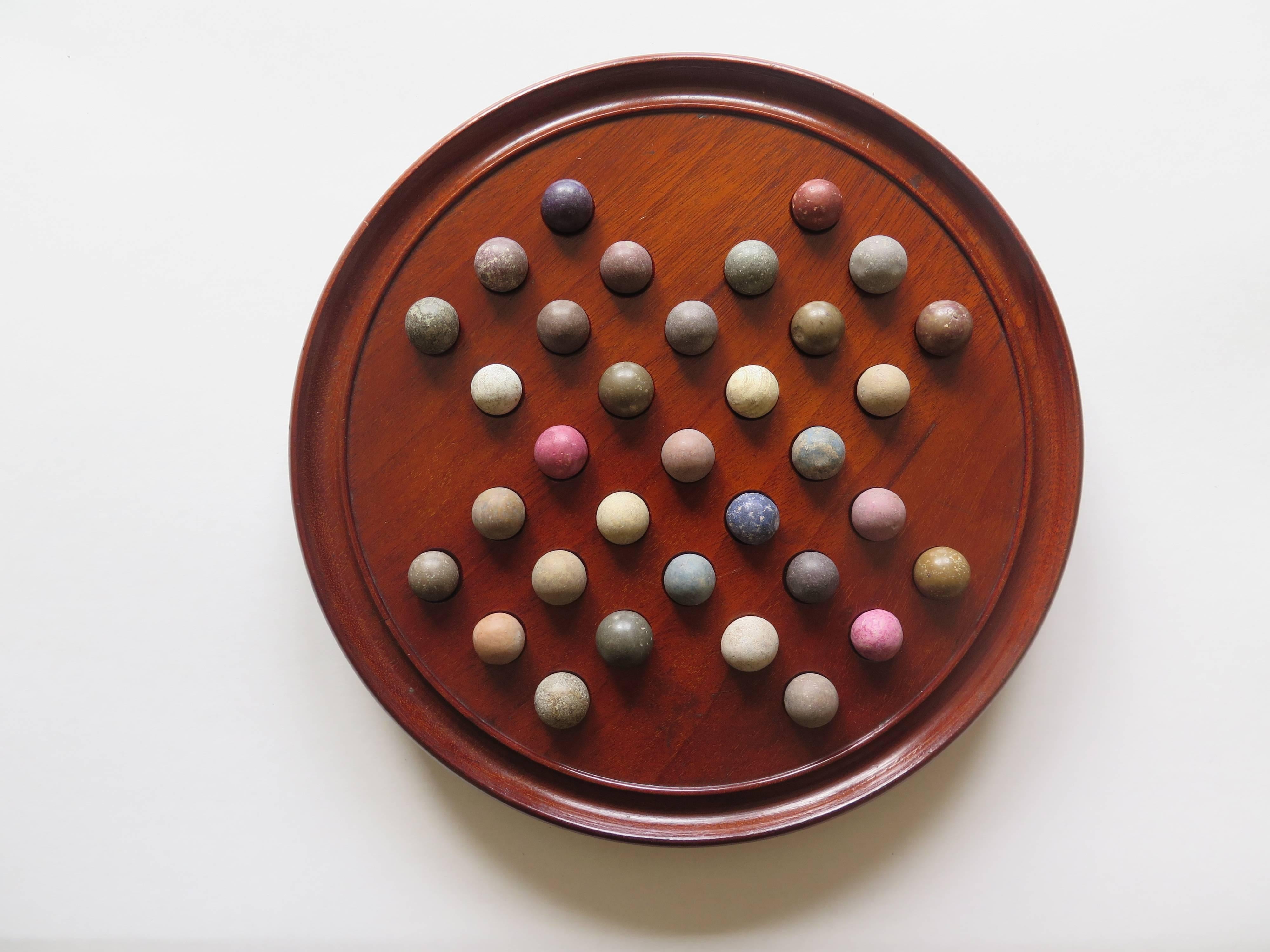 This is an original and complete Game of Marble Solitaire from the 19th century. 

The circular turned board is made of Mahogany and sits on three small wooden bun feet. The board has 32 equi-spaced holes with an additional one in the centre and a