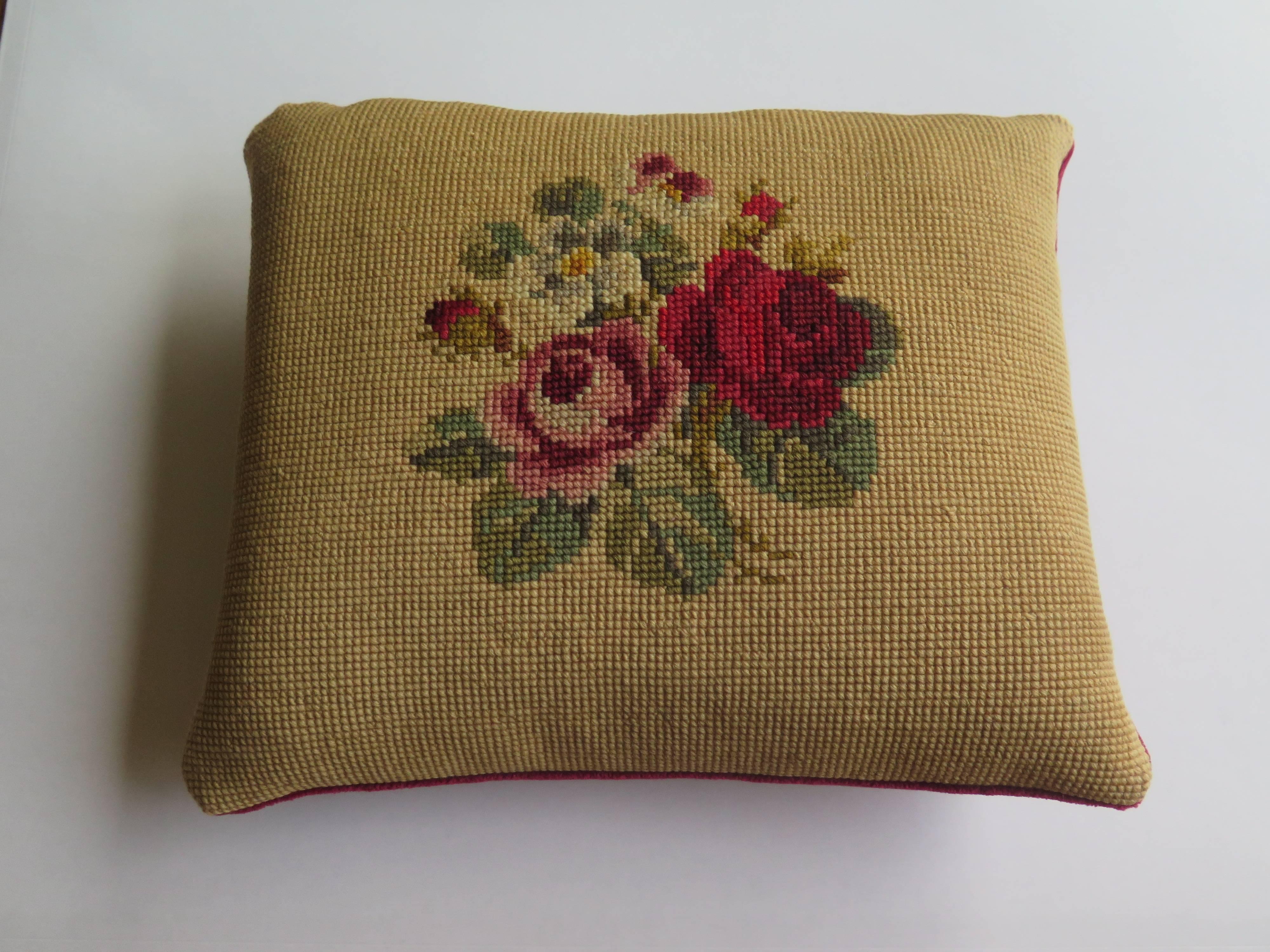 This is a small size, English, Art Nouveau inspired, Victorian needlepoint tapestry cushion or pillow from the late 19th century. 

The hand worked design shows rich red, plum and soft pink rose plumes with green foliage on an old gold background