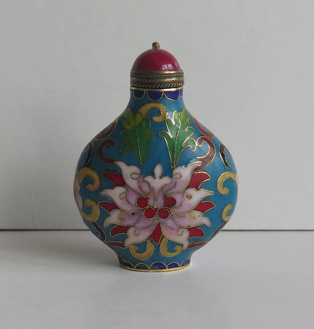 This is a very good example of a Chinese snuff bottle, made from cloisonné with hand enameled decoration.

The main decoration is of a large central stylized Lotus flower set within leaves with a similar flower to the reverse and small flowers to