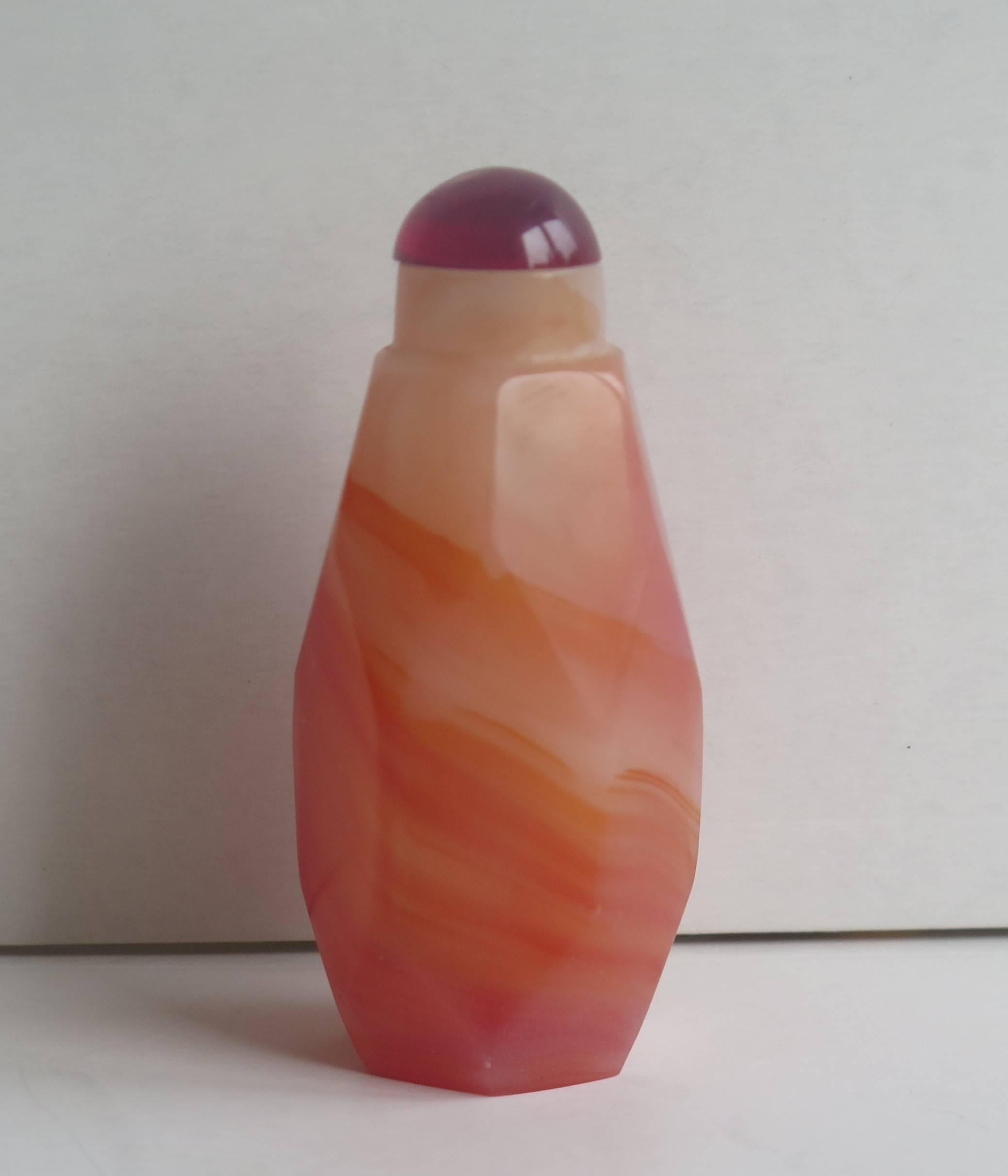 This is a good and very decorative Chinese snuff bottle, made from a natural salmon coloured agate stone and dating to the mid-20th century, circa 1940.

The bottle is made of hand-carved red agate which is a natural hard stone. The bottle is