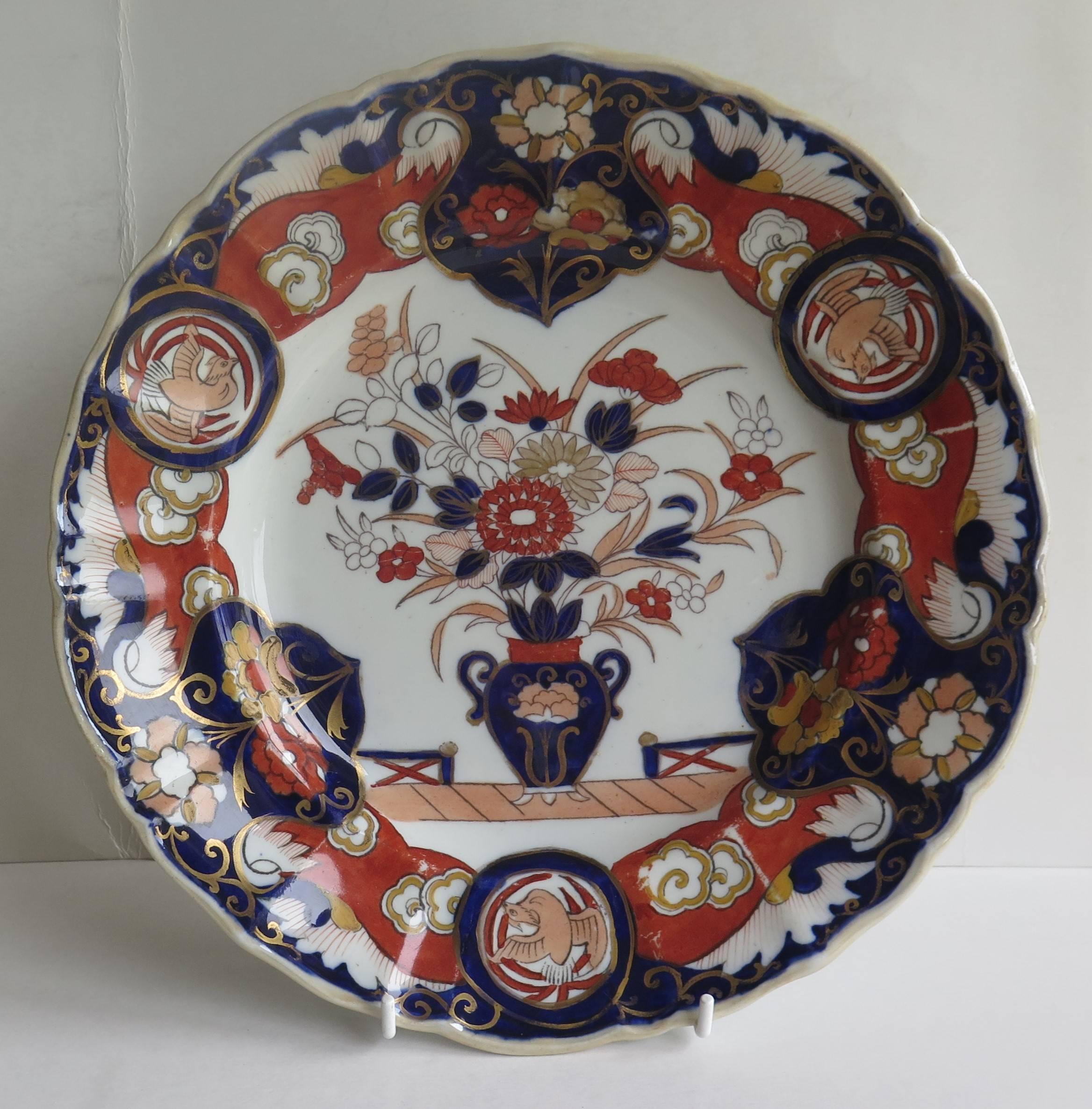 This is a very attractive large Dinner Plate made by the Mason's Patent Ironstone China Pottery Company in the early part of the 19th Century.

This plate is decorated in the: Fence Vase and Dove pattern, which shows a central flower filled vase,