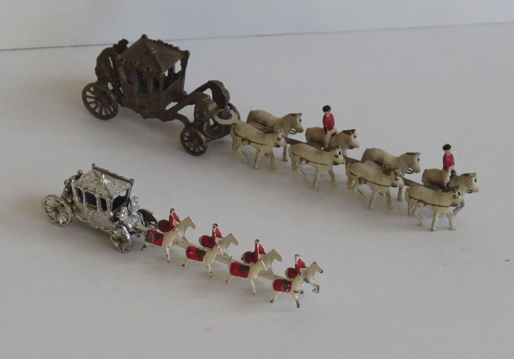 These are two different commemorative models or toys made for the Coronation of Queen Elizabeth II, in 1953.

Both models show the royal carriage being drawn by a team of eight horses. The wheels turn on each carriage and the horse section hooks