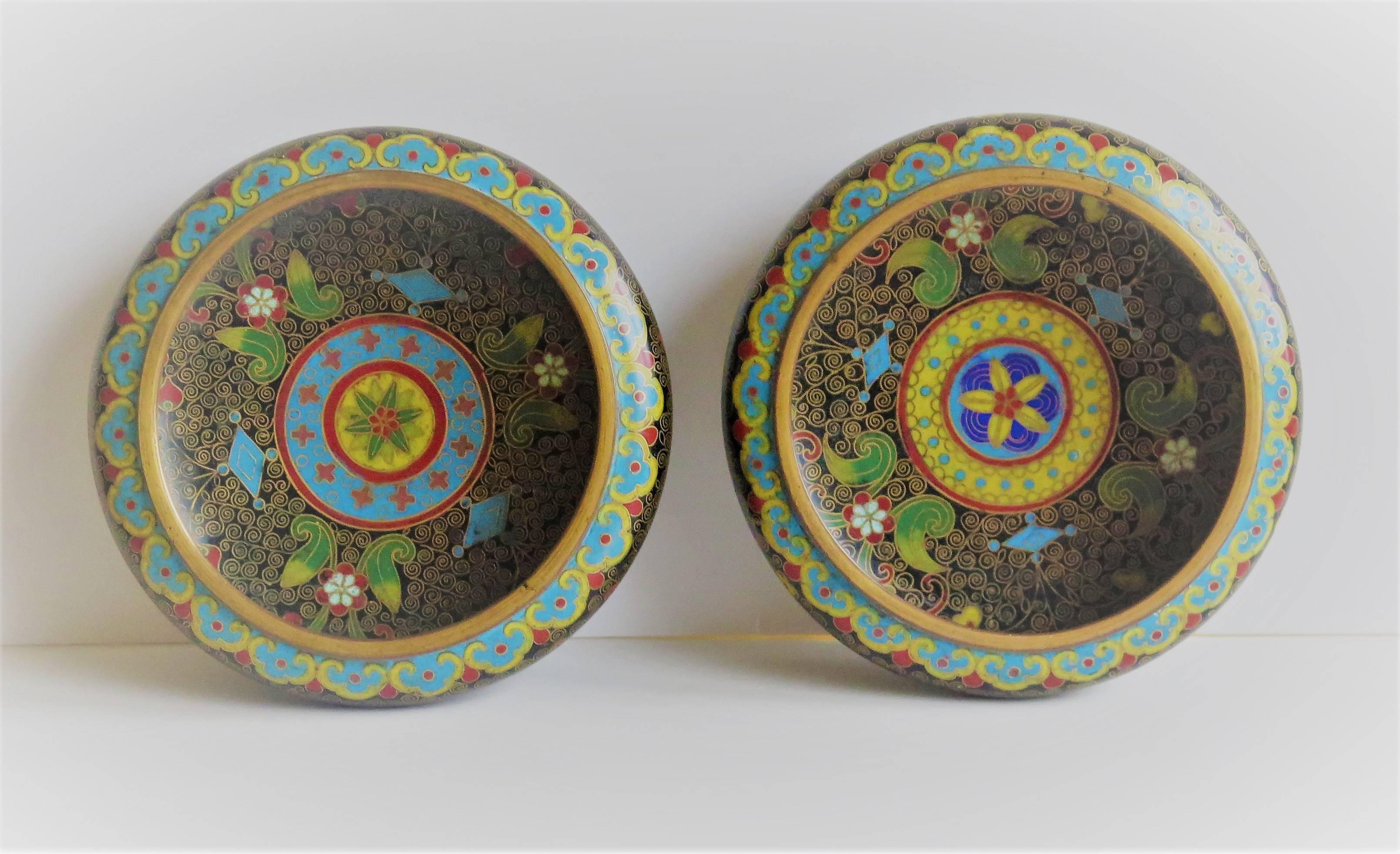 These are a good PAIR of shallow cloisonne bowls made in China in the mid-19th century.

Each bowl is circular with a short foot. They are beautifully made of bronze with rich colorful enamels in different but very similar designs.

The decoration
