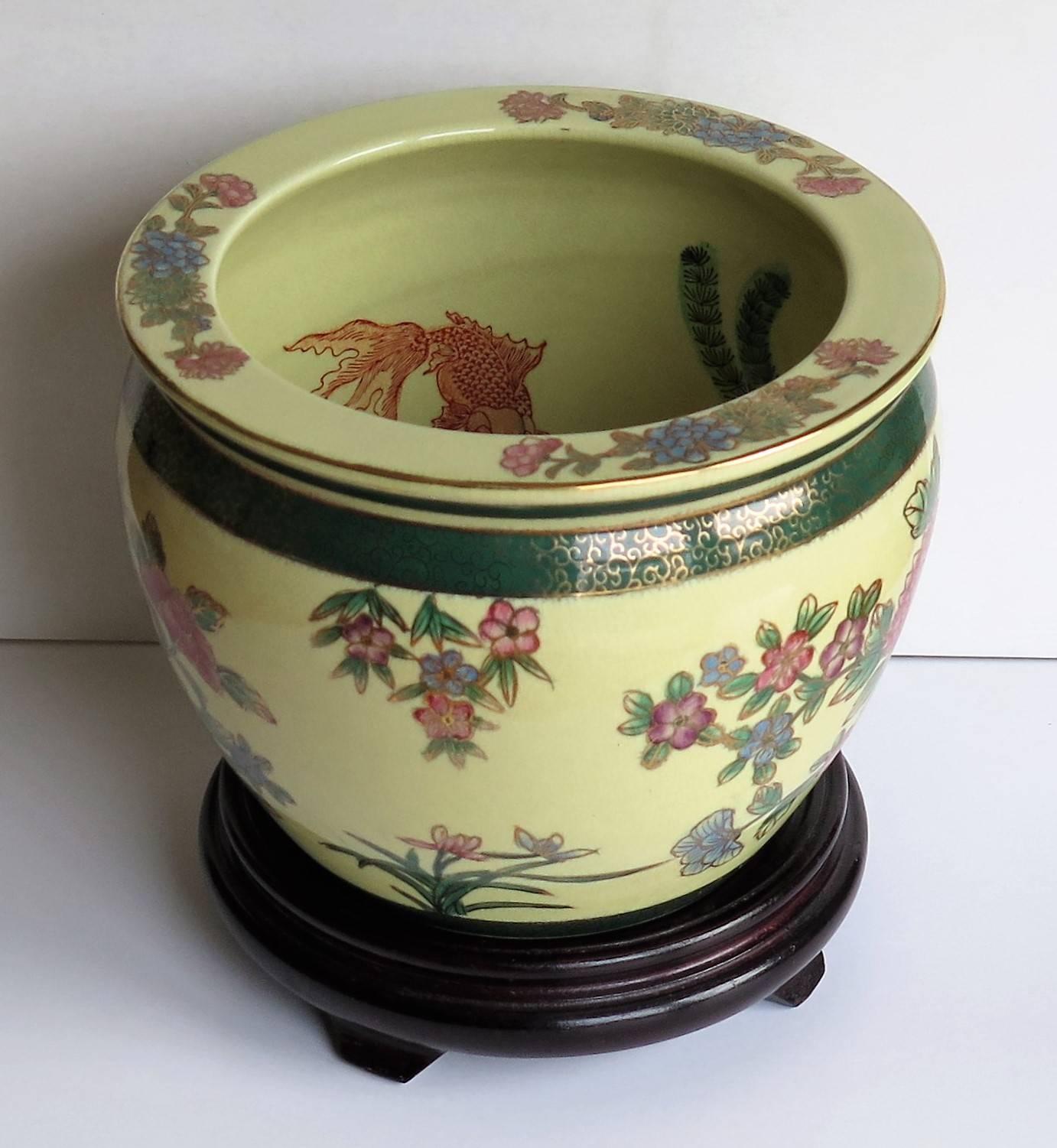 This is a very good porcelain fish bowl or jardiniere complete with its own wood stand.

The bowl is well potted and heavy, weighing over 2kg unpacked. 

The bowl is hand-painted outside and inside; to the outside are Peony and other flowers,