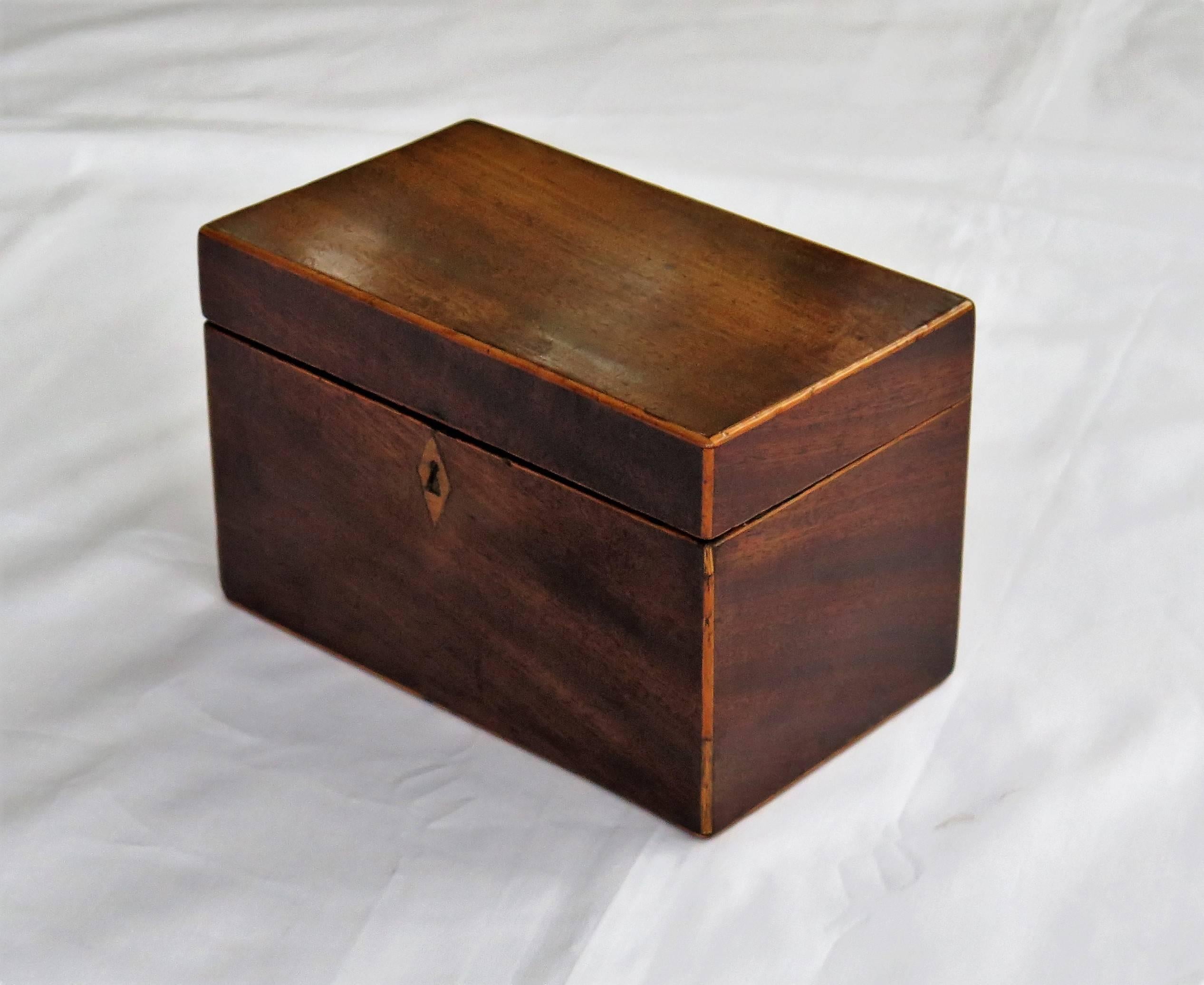 This is a very nice quality English Georgian Period Tea Caddy.

The Tea Caddy is handmade of a well figured mahogany, with boxwood stringing applied to all of its external edges. The caddy has a lovely color and patination due to use, polishing and