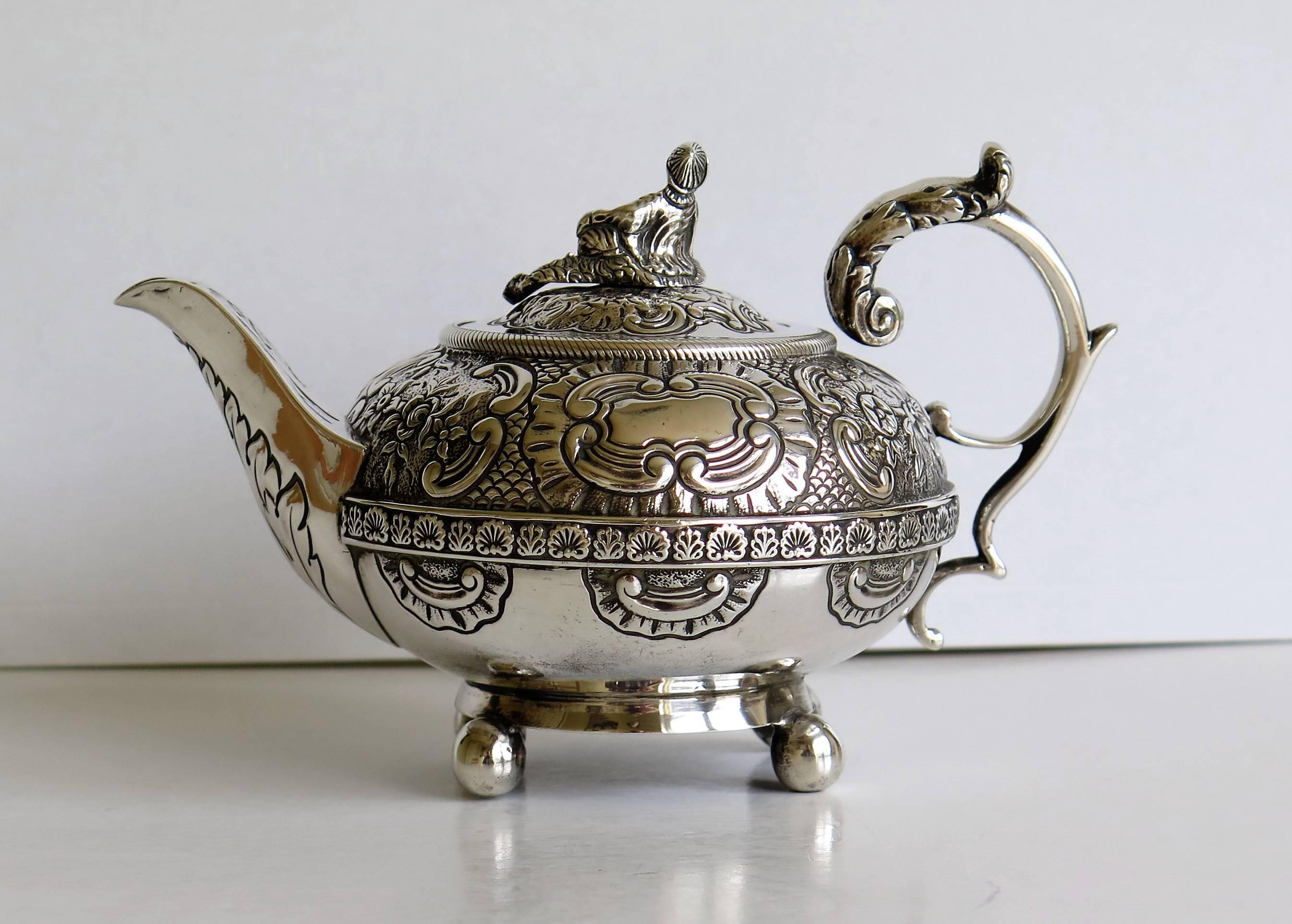 This is a fine quality Bachelors teapot in solid Sterling Silver, beautifully hand chased and dating to the late Georgian period of George 111rd, 1817.

The teapot has a circular compressed form, supported by four small ball feet. It has a solid