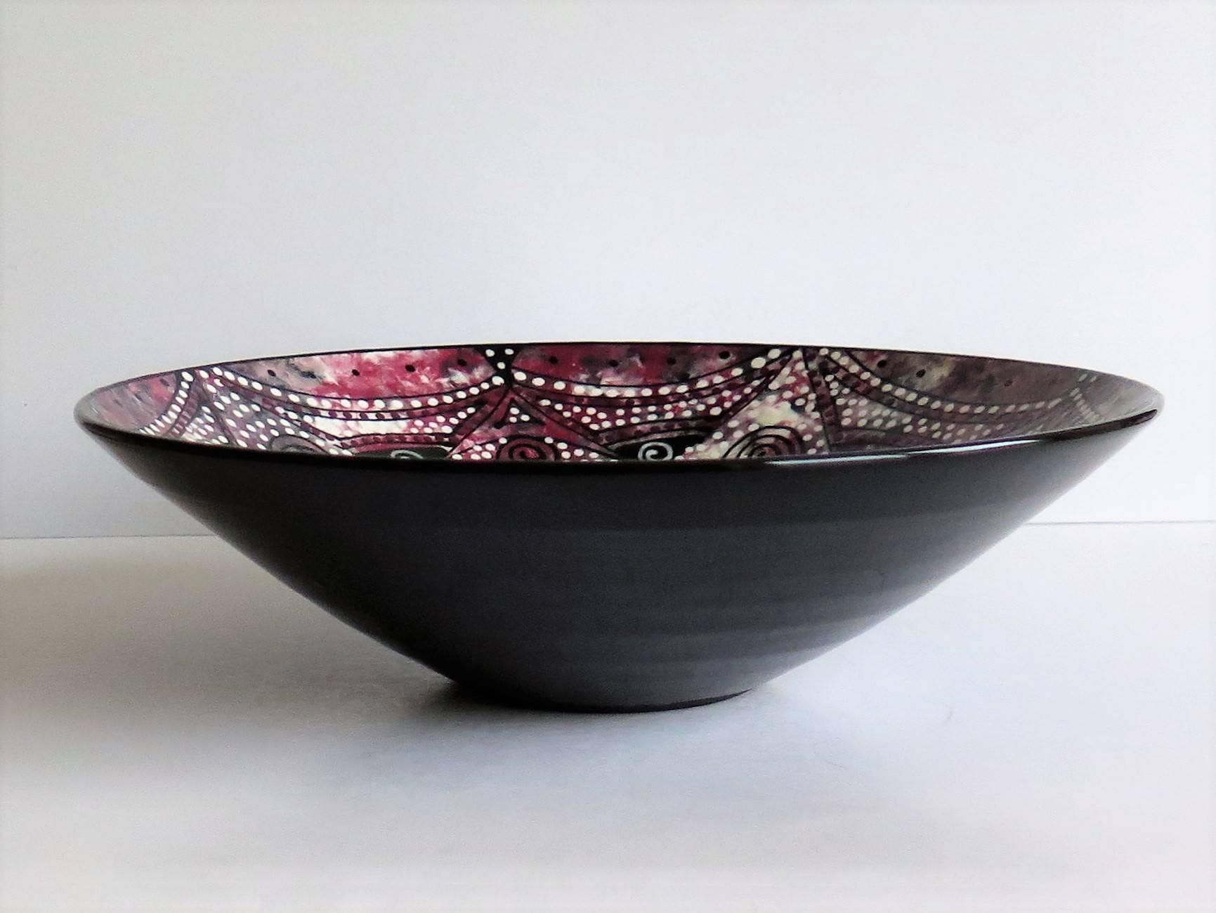 This is an unusual, beautiful and very decorative, Studio Pottery bowl.

The bowl is hand thrown and finely potted.

It is hand painted to the inside with a mottled dappled effect using colors which include white, grey, blue, red, pink, all in