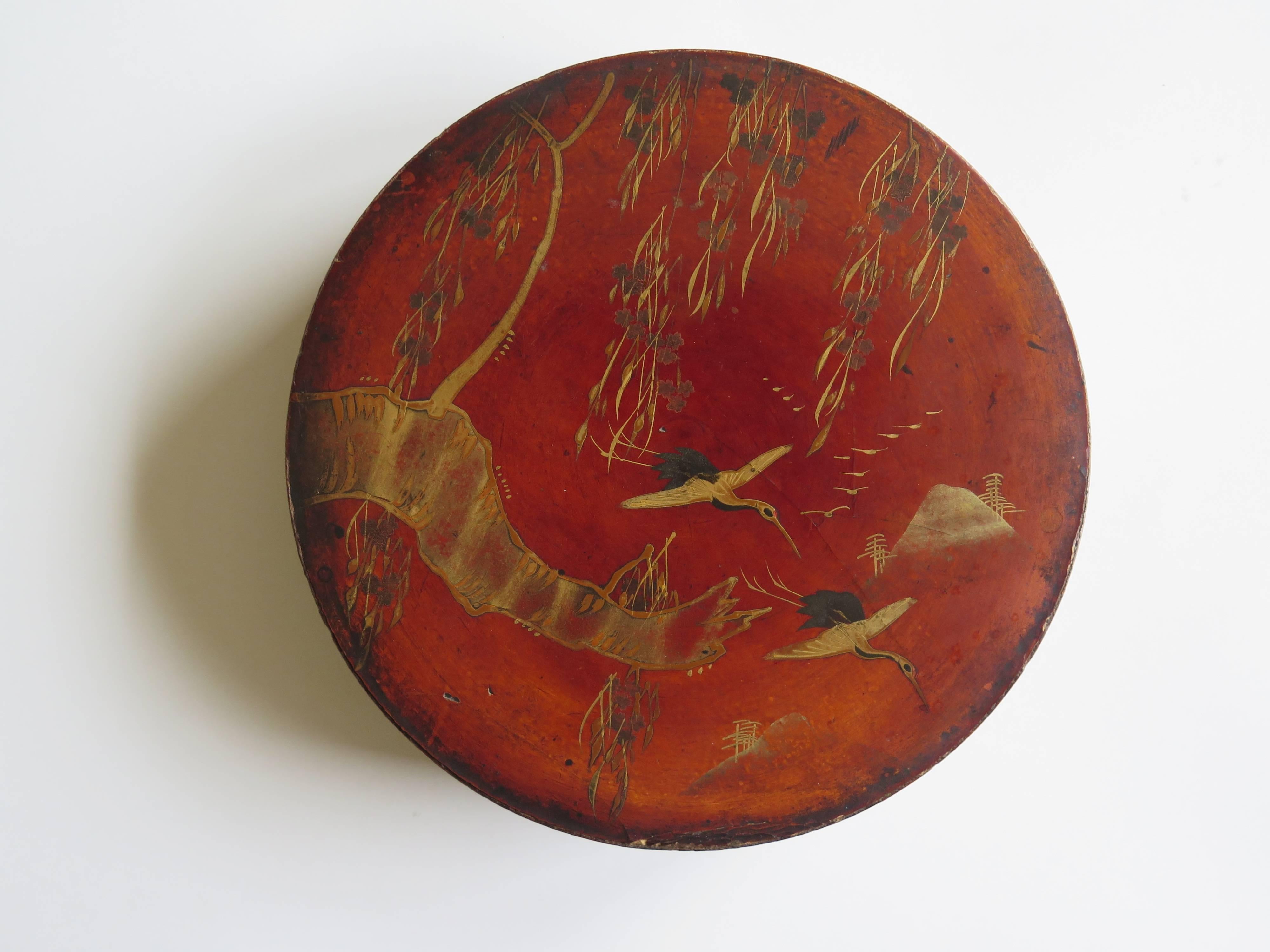 This is a beautiful papier mâché, large circular lacquered box, which we attribute to being made in Japan during the mid-19th century.

This is a large and very decorative box with a delicately hand painted scene of two cranes in flight underneath