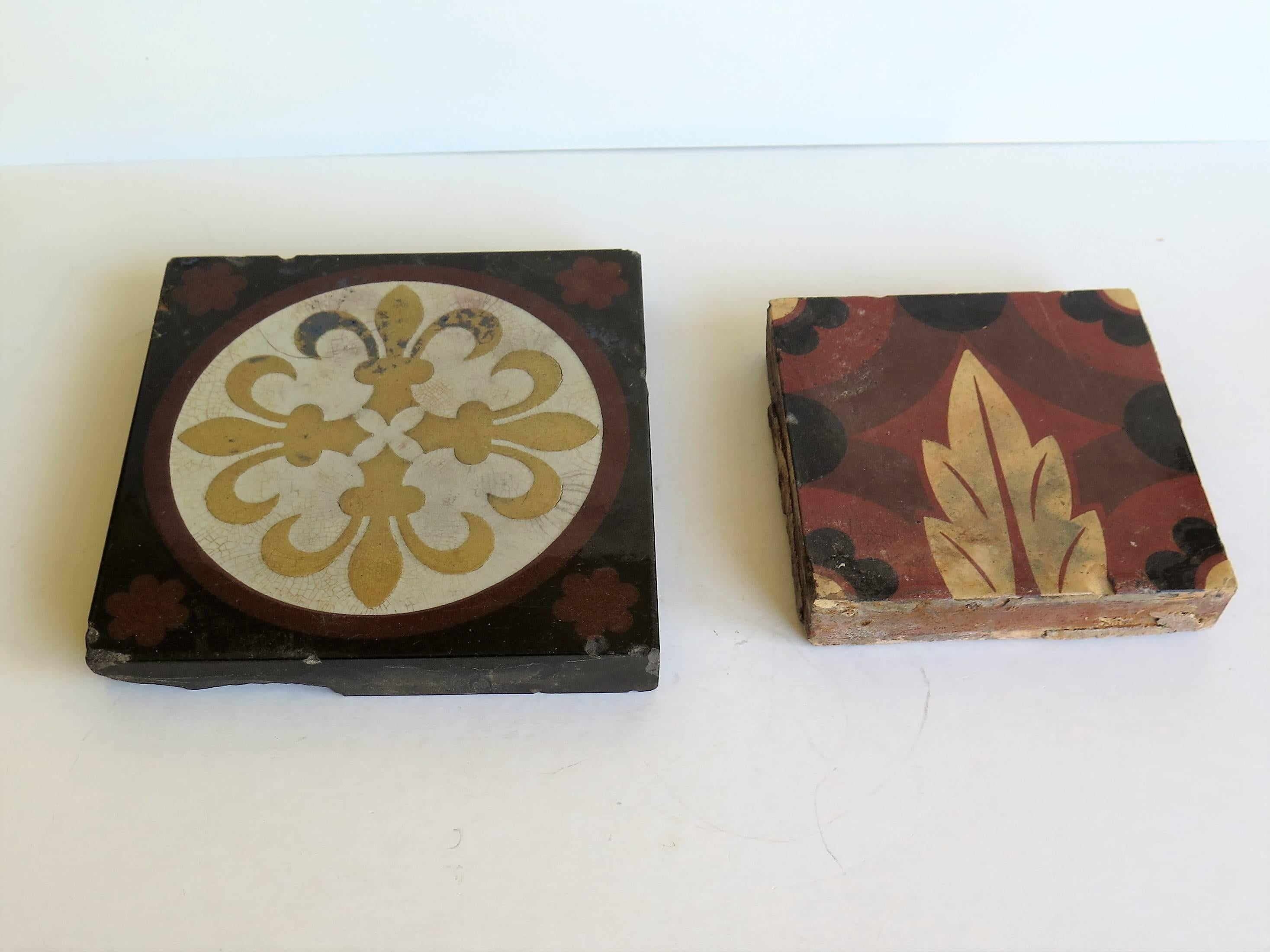 These are TWO decorative encaustic tiles from two different makers, dating to the 19th century, circa 1870. They were probably originally made as floor tiles. 

LARGER TILE: Dimensions; 6 x 6 x 0.85 inches
This larger tile is a beautiful pressed