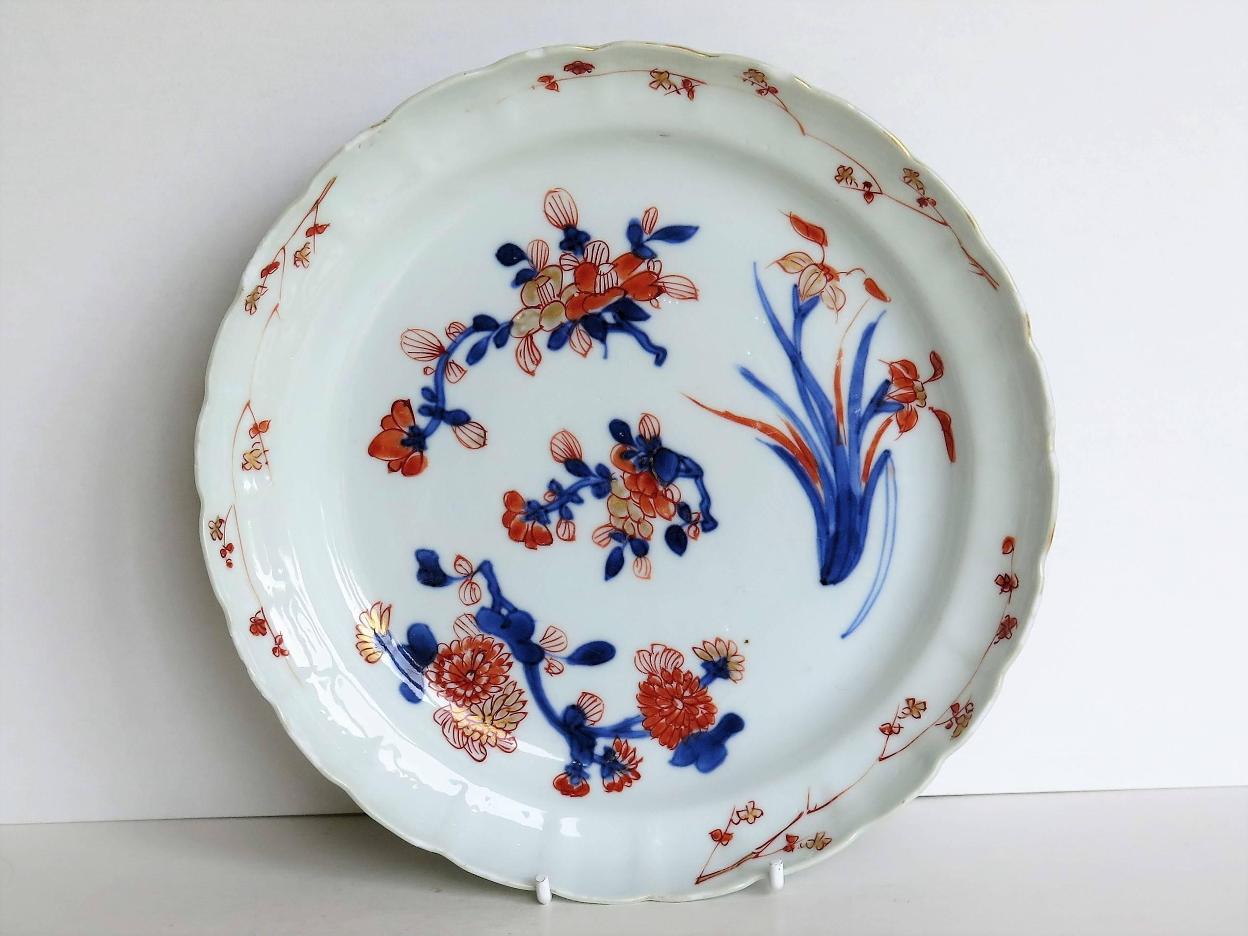 This is a fine Chinese porcelain plate or dish from the early 18th century, which we attribute as a piece made in the Imari style for the export market probably to Japan.

The dish is finely potted with a contoured and partially lobed edge around