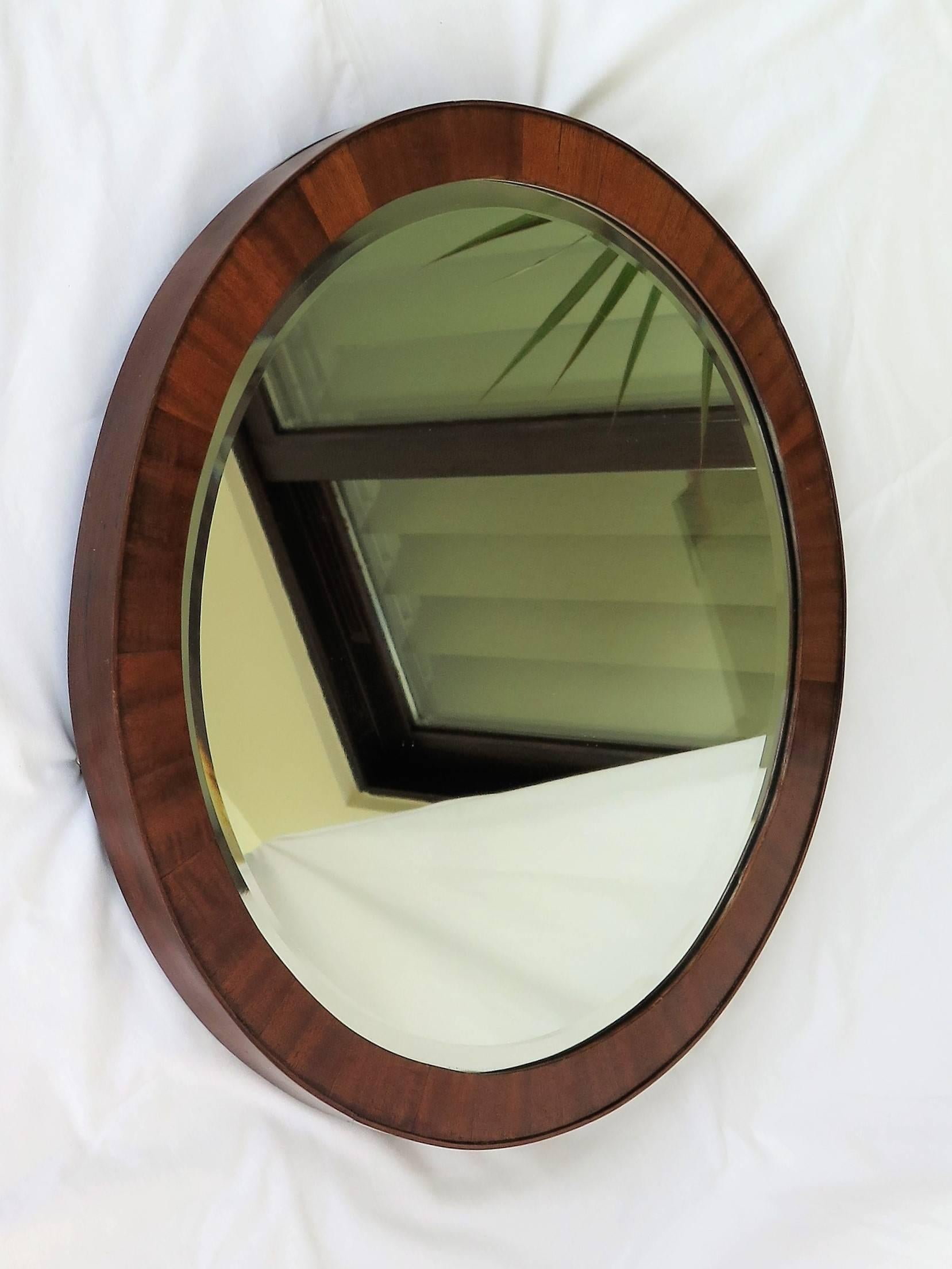 This is a beautiful round, English, Victorian, Wall Mirror, dating to the mid 19th Century.

The frame is made of mahogany with crossbanded sections inlaid into its periphery, meeting the outer side edge, which overlaps the front slightly, giving