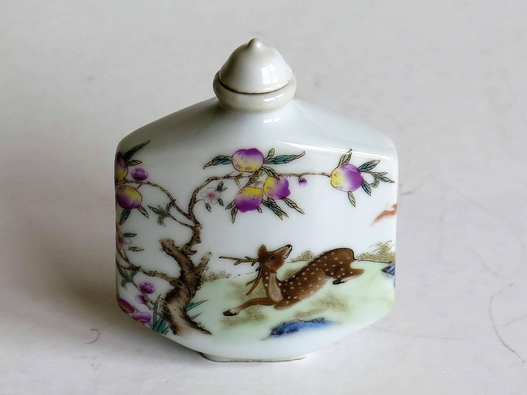 This is a very decorative, hand-painted, Chinese Export, porcelain snuff bottle, circa 1940s. 

The bottle has a low shaped foot and a nice tactile rectangular shape which curves to the front and back faces. It has a narrow neck with a cone shaped