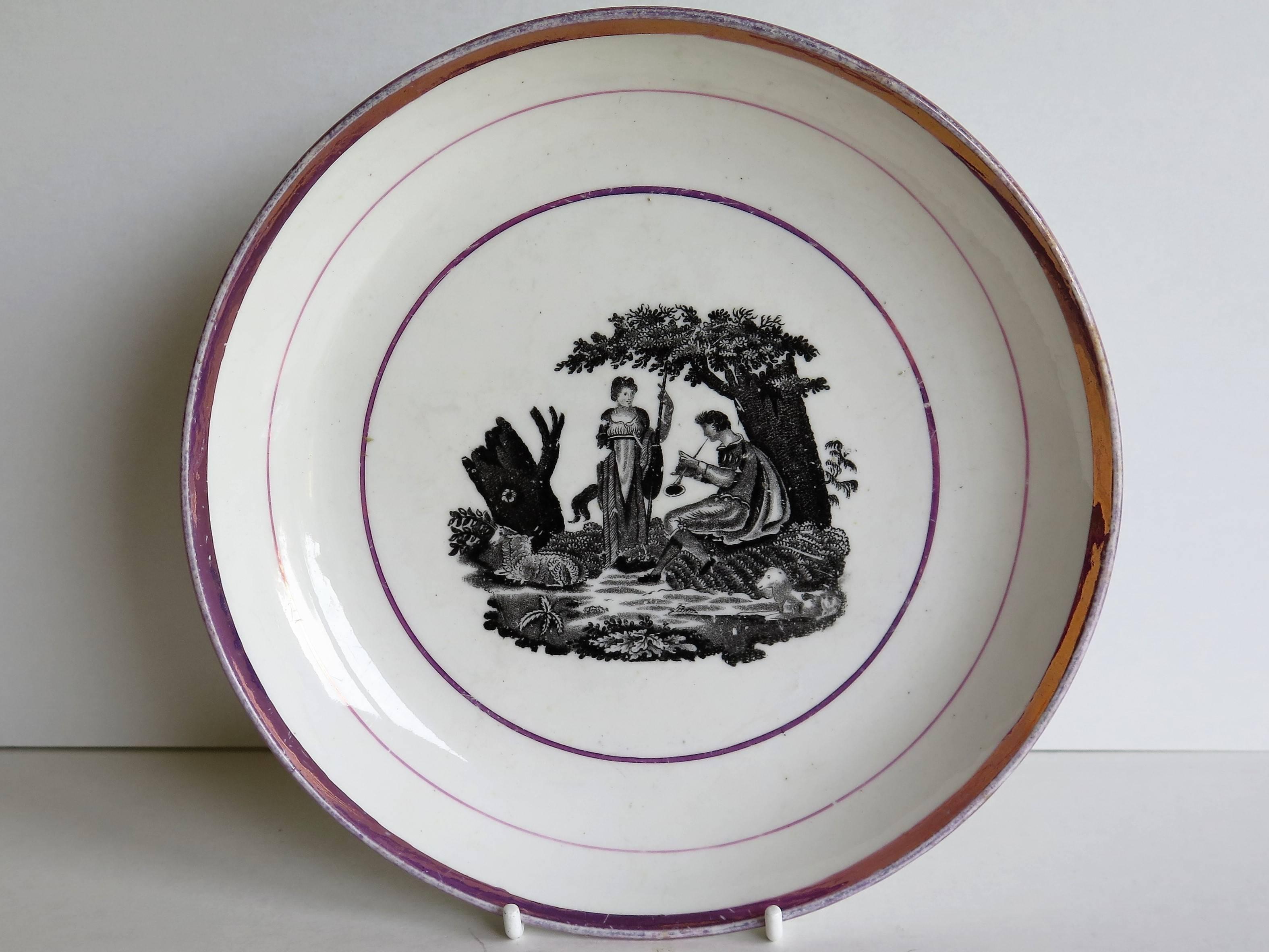 This is a good porcelain Sunderland pink lustre dish or deep plate from very early in the 19th century, George III period, circa 1810.

The dish is decorated with a classical bat printed scene of a lady in a woodland setting being serenaded by a man