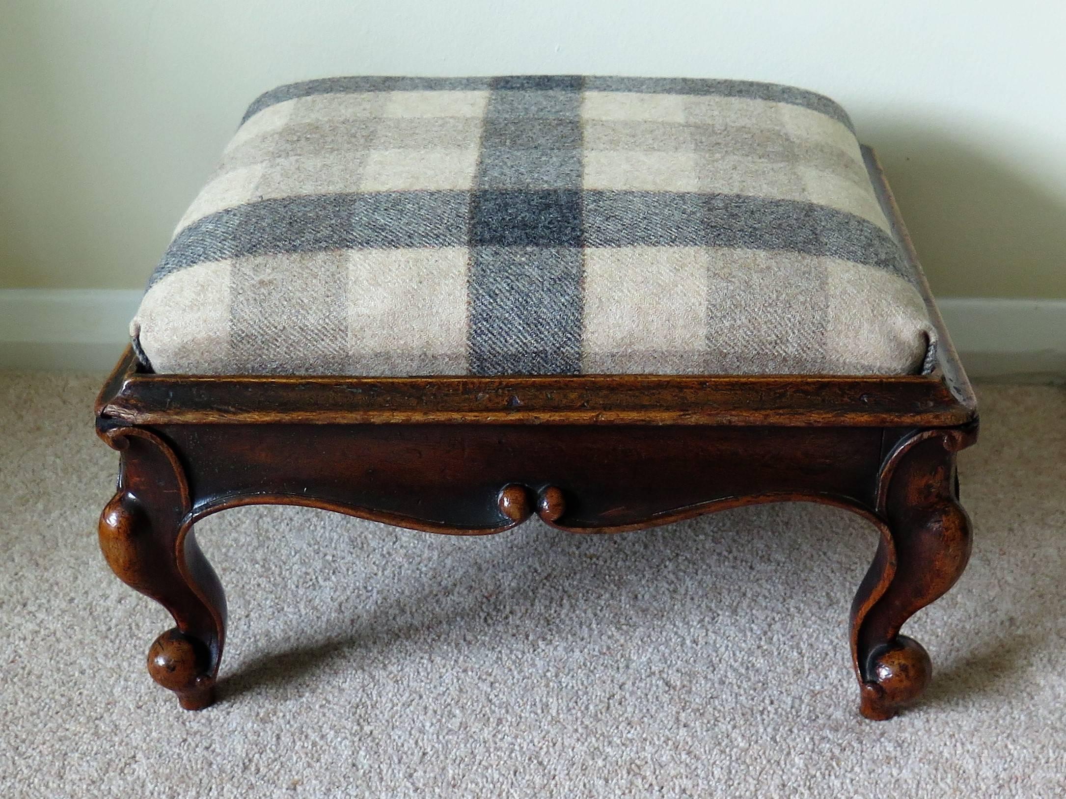 This is a very good quality English Victorian period, large mahogany stool or foot stool, circa 1850

The stool is rectangular in shape with a carved solid mahogany frame having curved and outward splaying sides and four short cabriole legs, typical