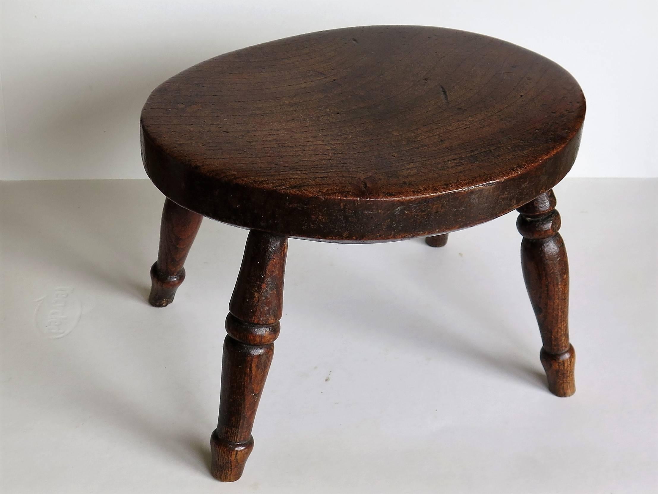 This candle stand or stool is a good example of English Country furniture.

The thick oval top is made of solid elm and has a lower chamfered edge. The legs are also made from elm and are well turned, splaying slightly outwards. The legs have