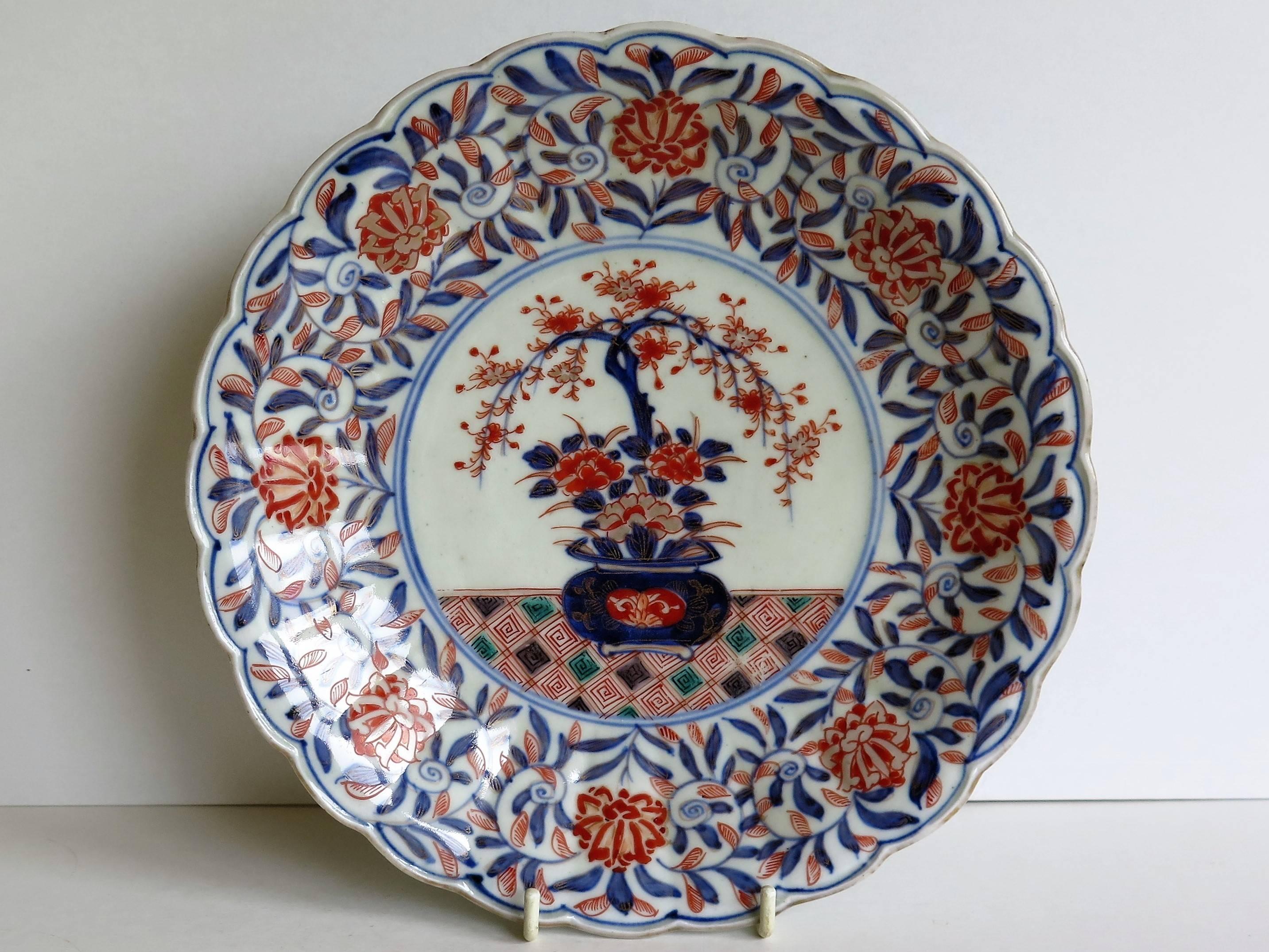 This is a nice quality Japanese Porcelain deep plate or dish with an Imari pattern, dating to the mid-19th century, or possibly earlier.

The plate is decorated in varying shades of under-glaze cobalt blue, then hand enamelled with blue, burnt